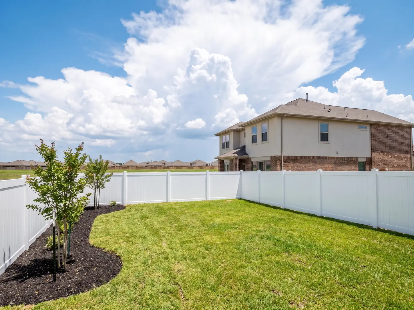 New white vinyl privacy fence around a modern two-story home in a Pearland, TX master-planned community
