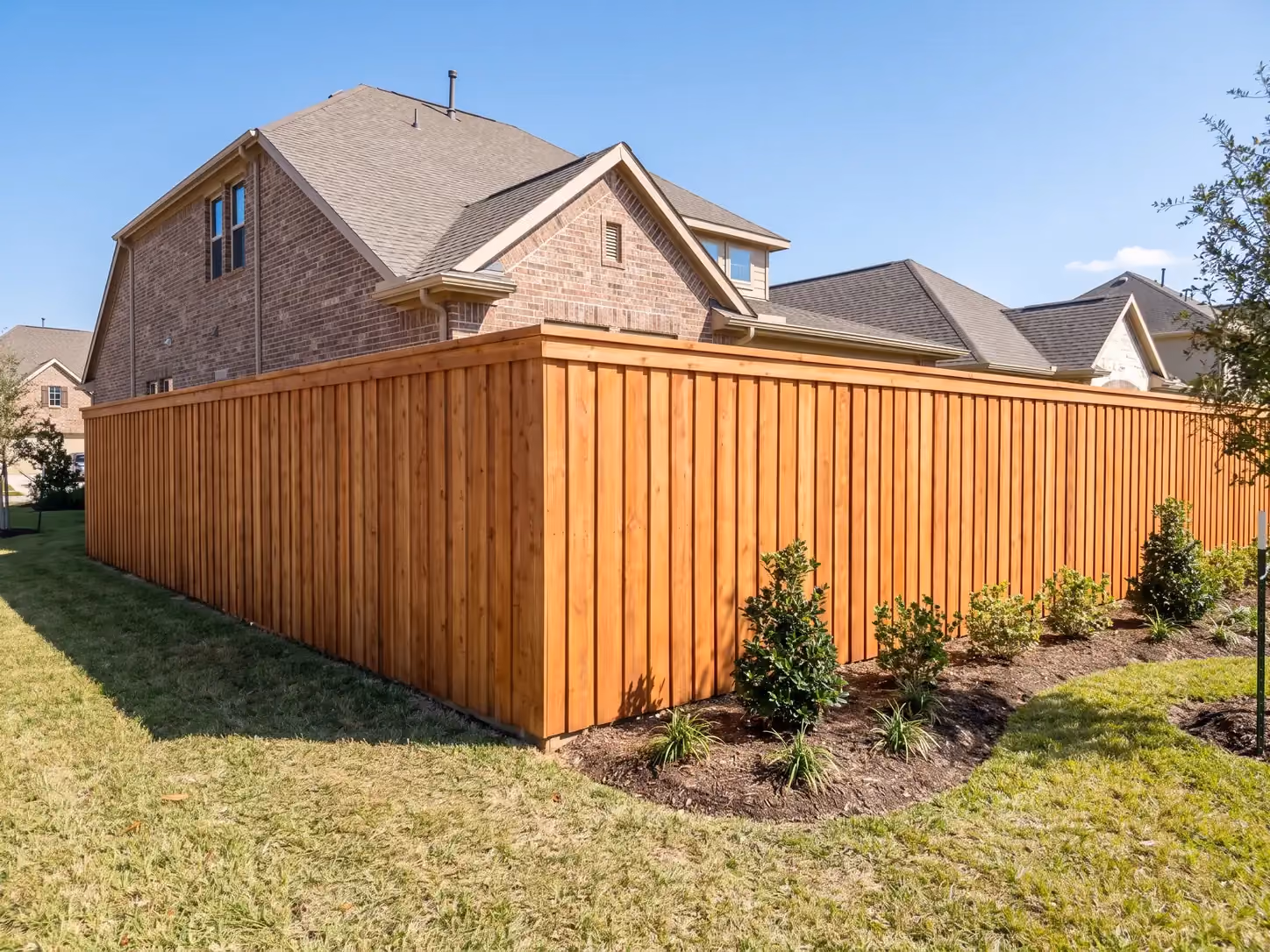 Newly installed cedar board-on-board privacy fence around a Houston suburban backyard