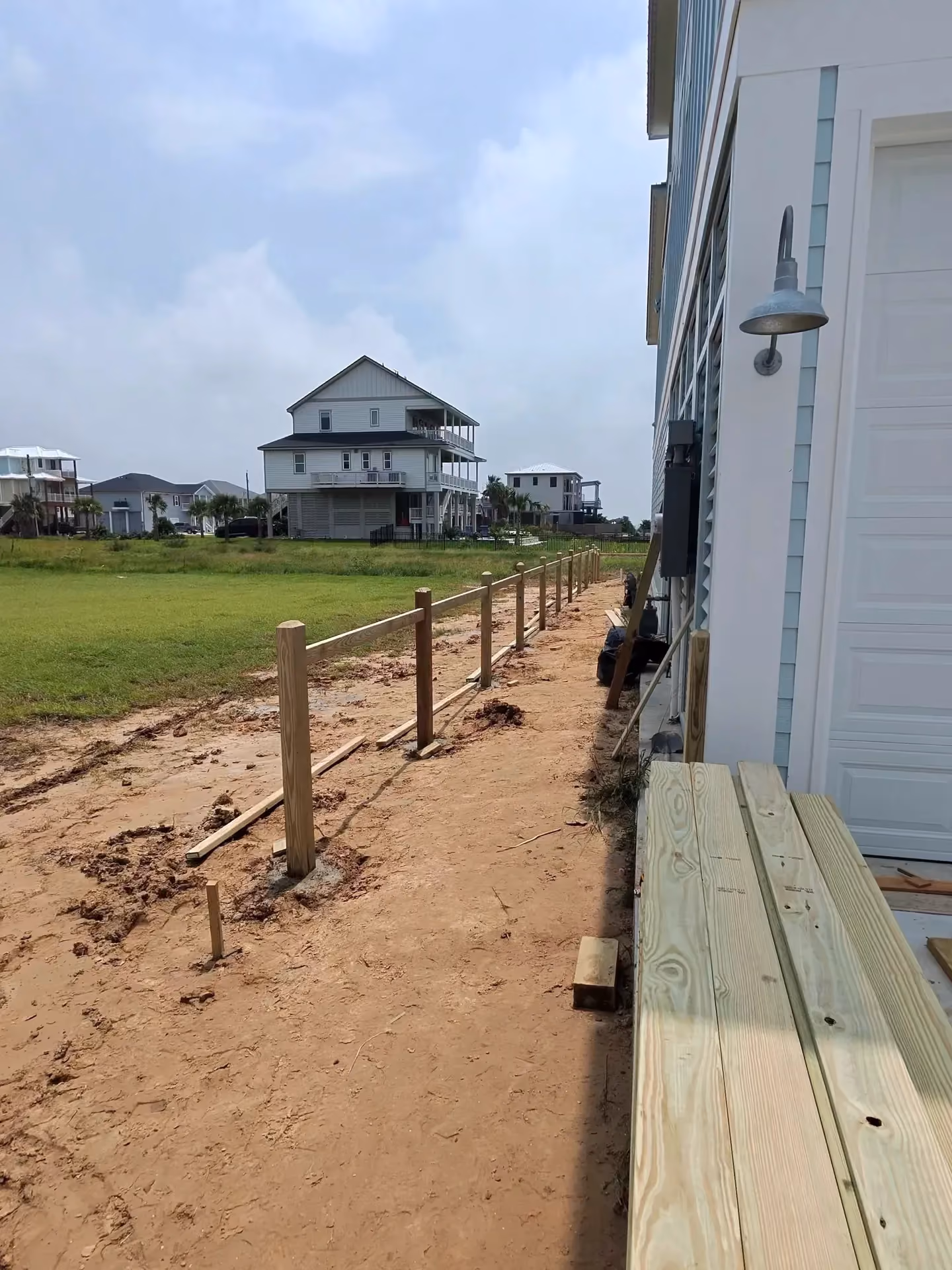 New wood posts and rails take shape along a sandy beach lot on the Texas Gulf Coast.