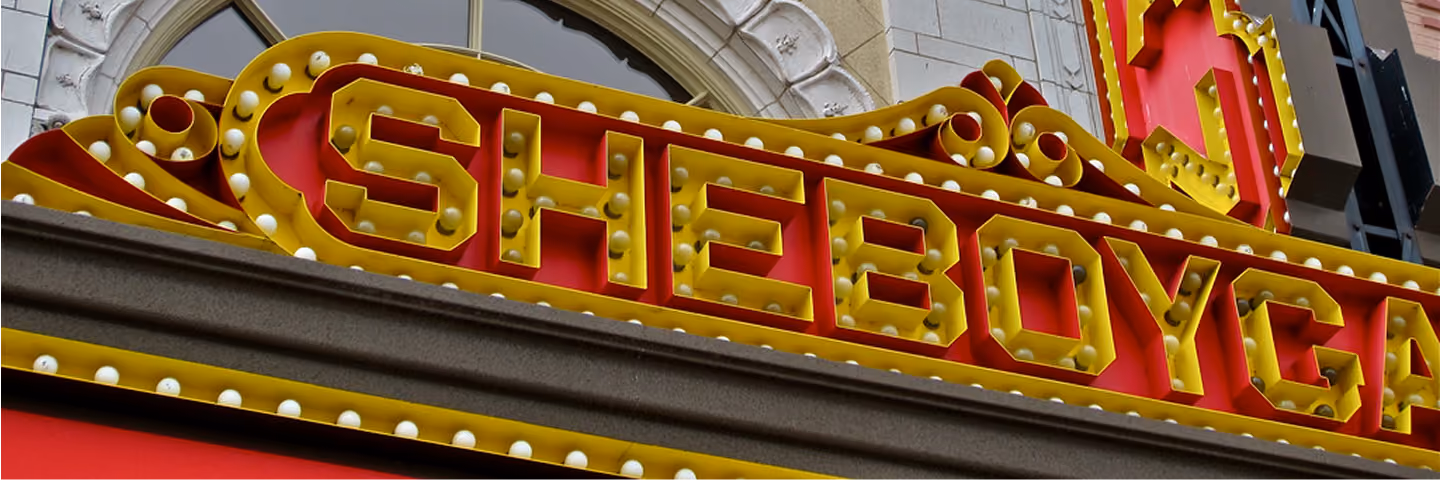Close-up of a red and yellow marquee sign with the word SHEBOYGAN in bulb-lit letters.