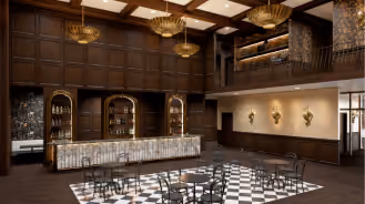 Luxurious lobby with marble reception desk, checkered floor, dark wood paneling, and chandelier lighting.