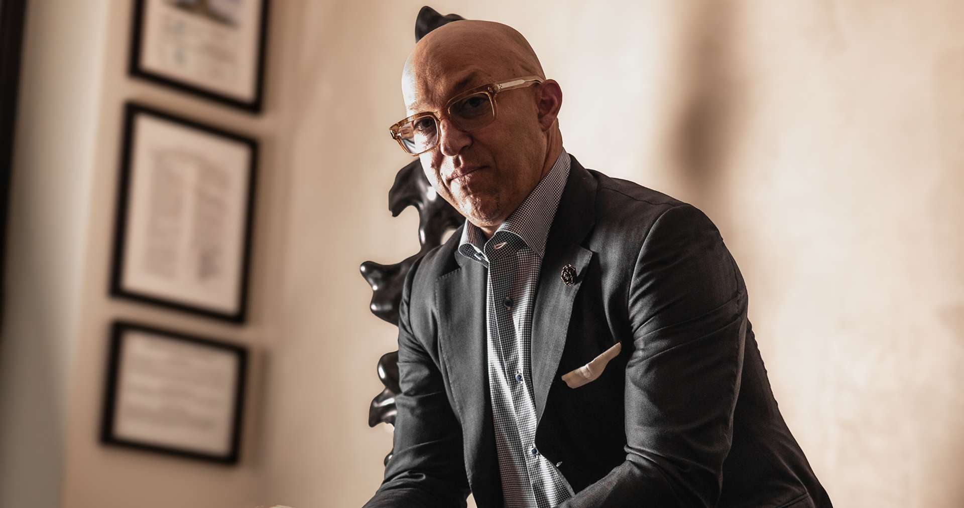 Portrait of Dr. Vallecillos in a suit, seated in his office