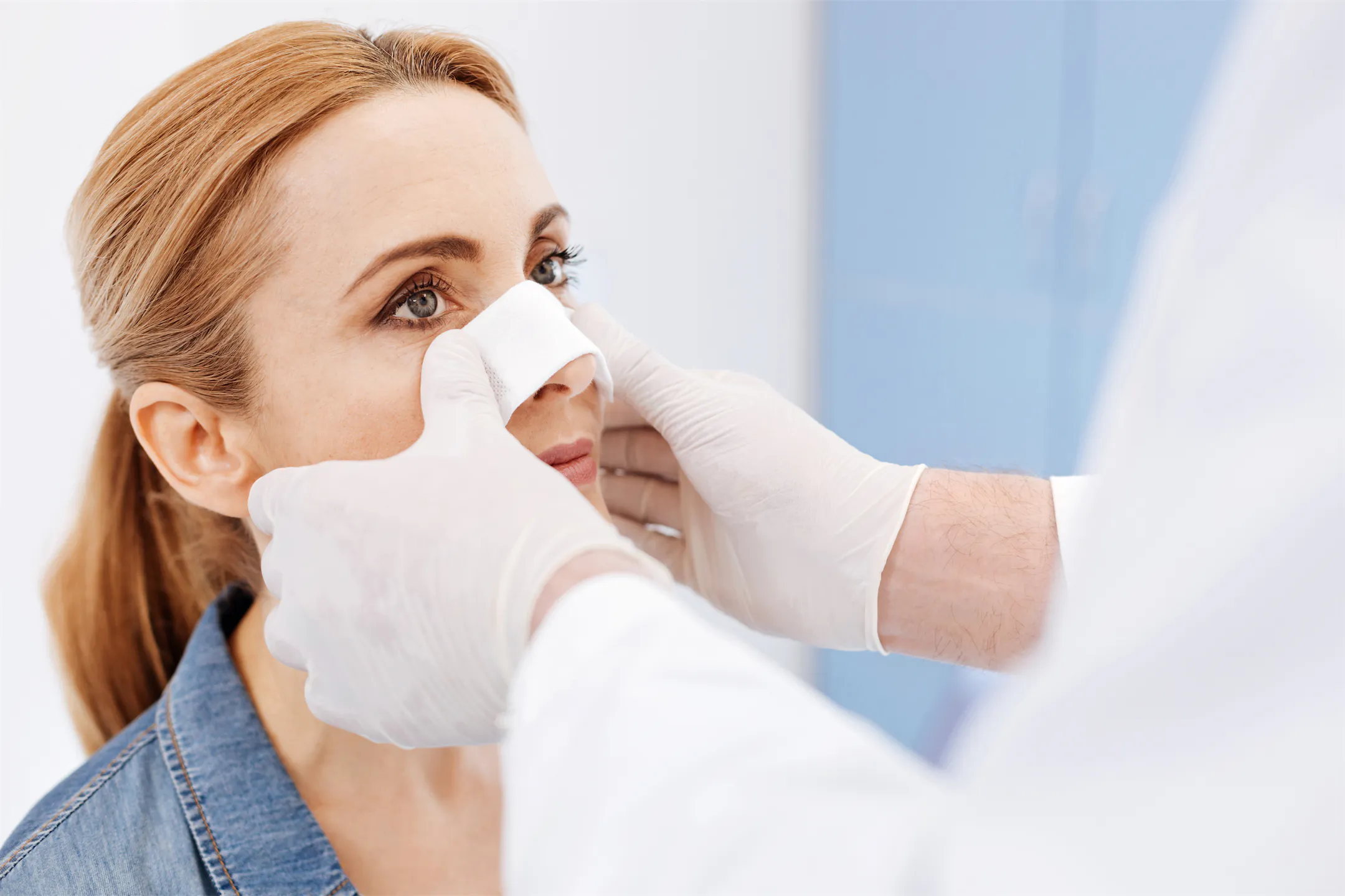 Provider placing a protective nasal splint on a woman's nose