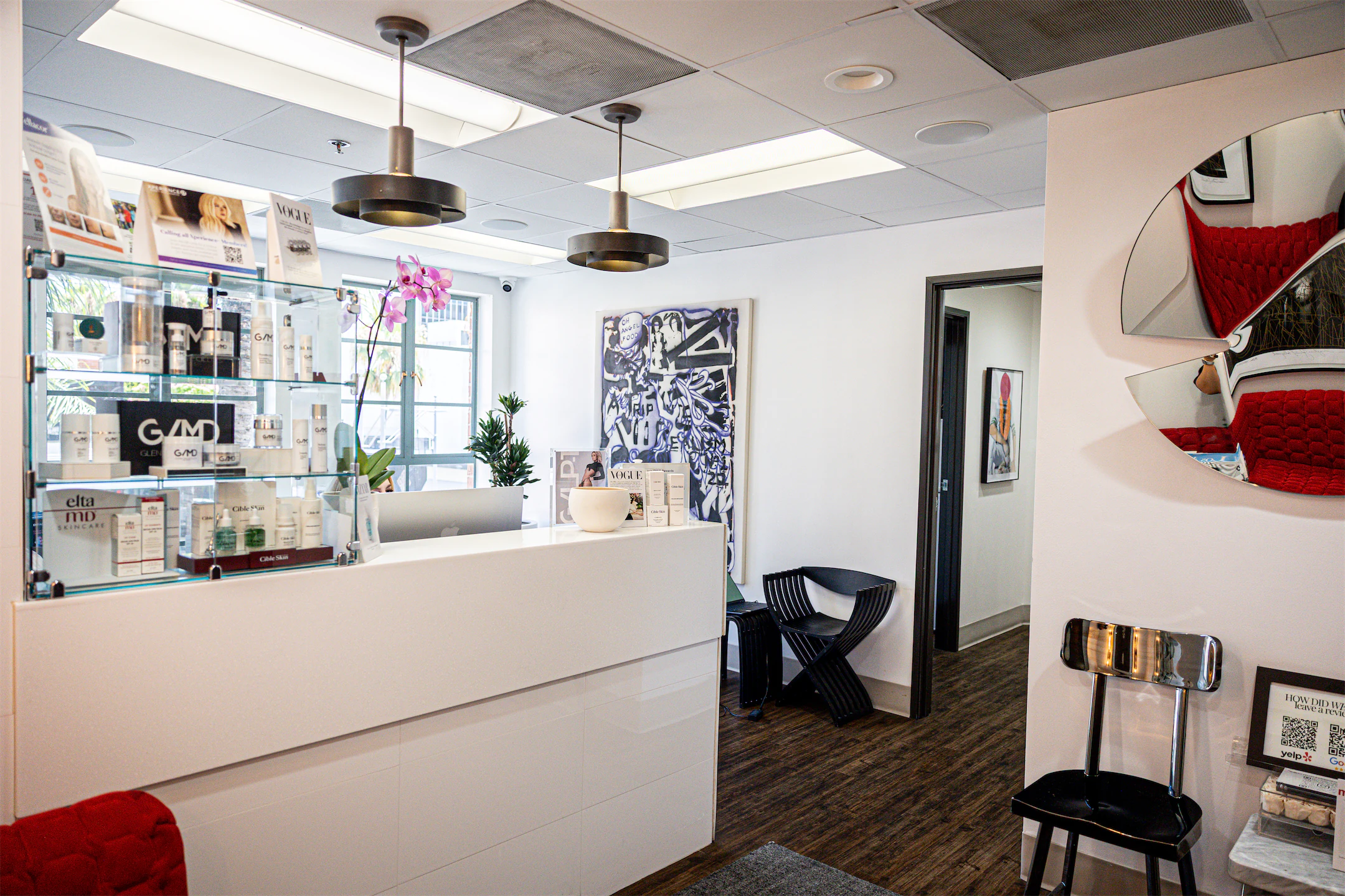 Bright reception area with a white front desk, product display, and modern art