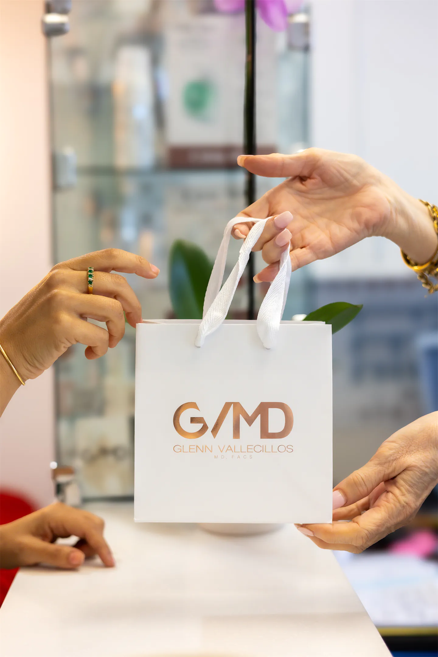 A GVMD-branded gift bag being handed across the front desk