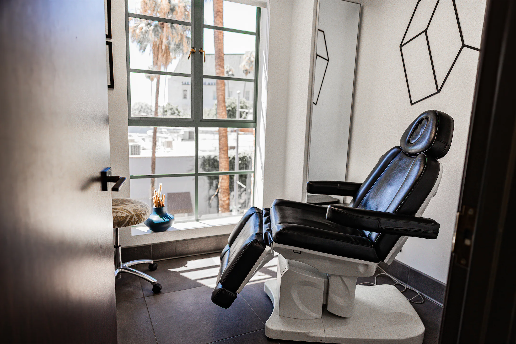 Treatment room with a reclining chair seen through a partly open door