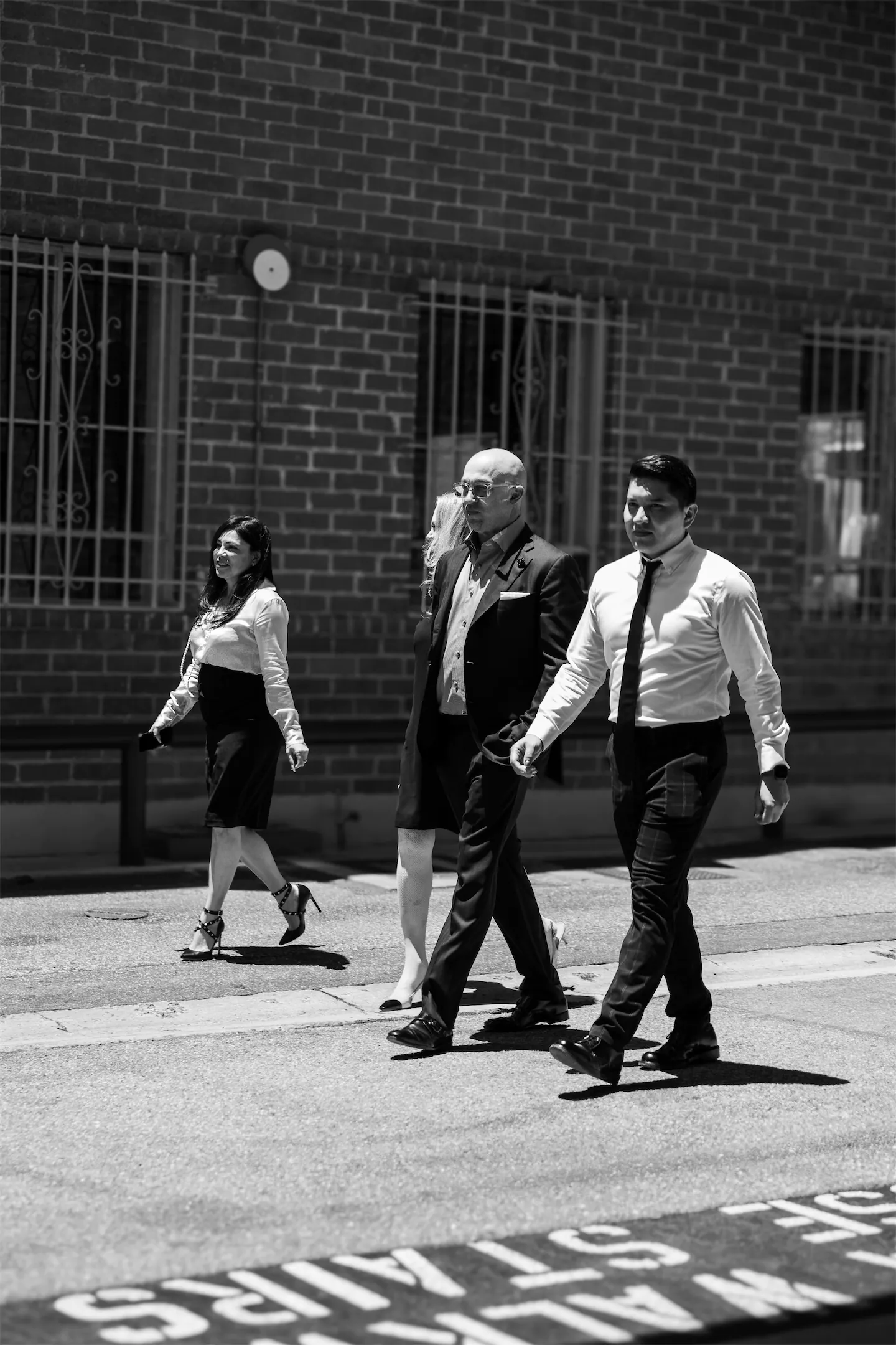 Black-and-white photo of four GVMD team members walking along a city street