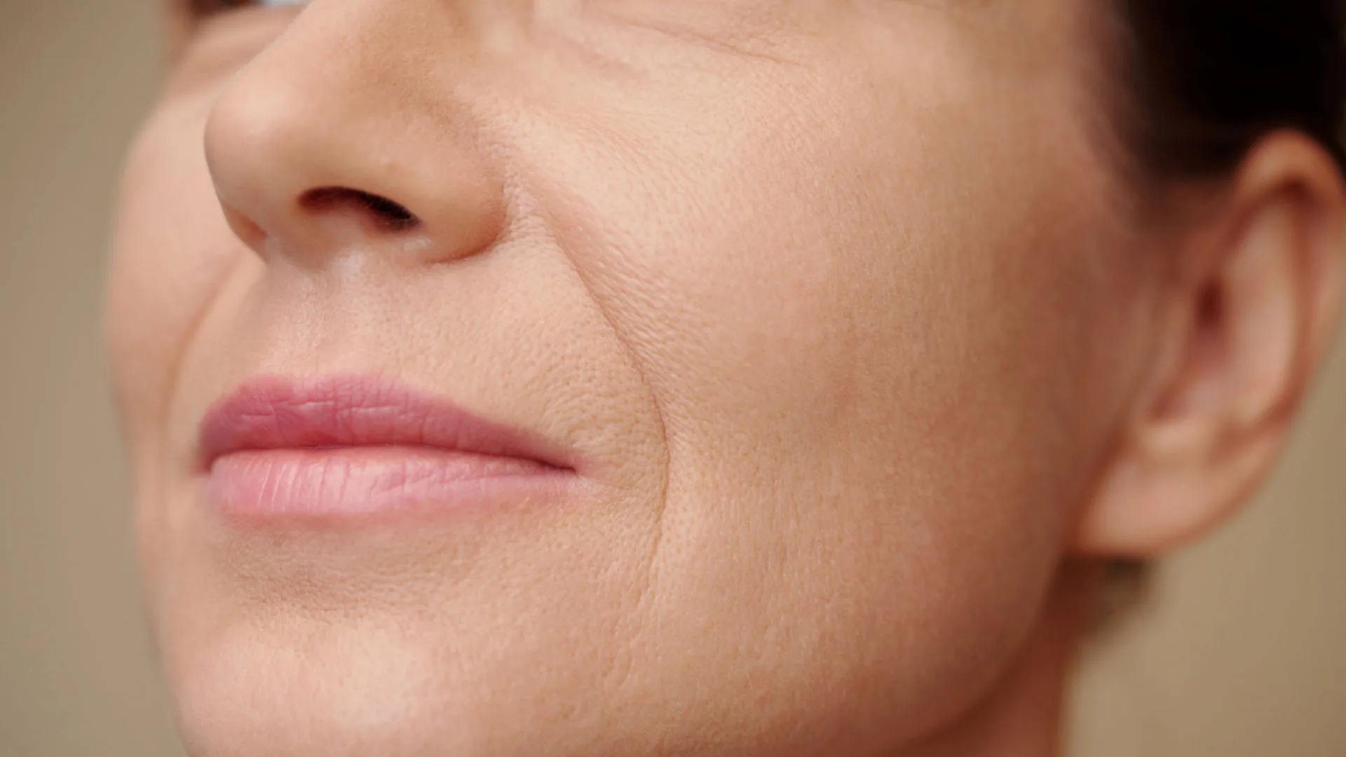 Close-up of a woman's nose, lips, and smile lines