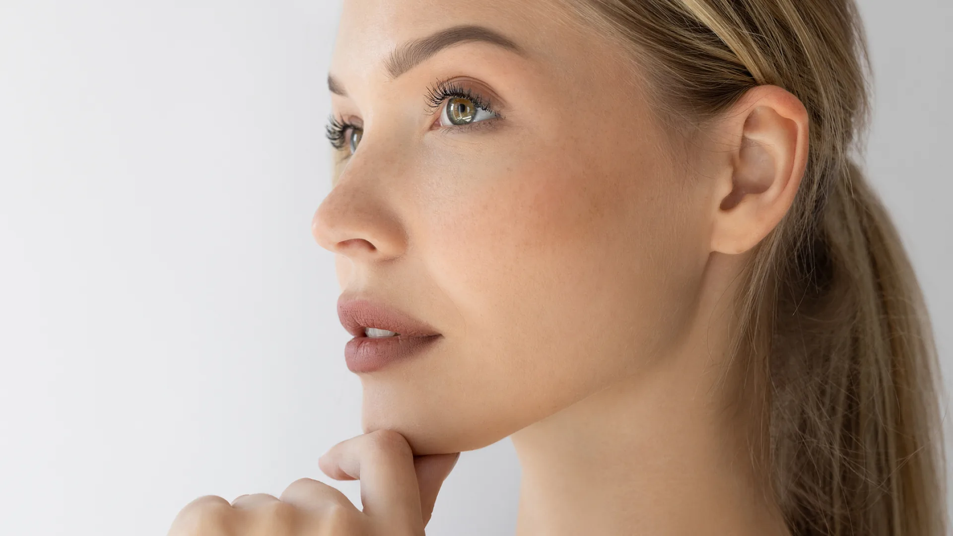 Woman in three-quarter profile with her chin resting on her hand