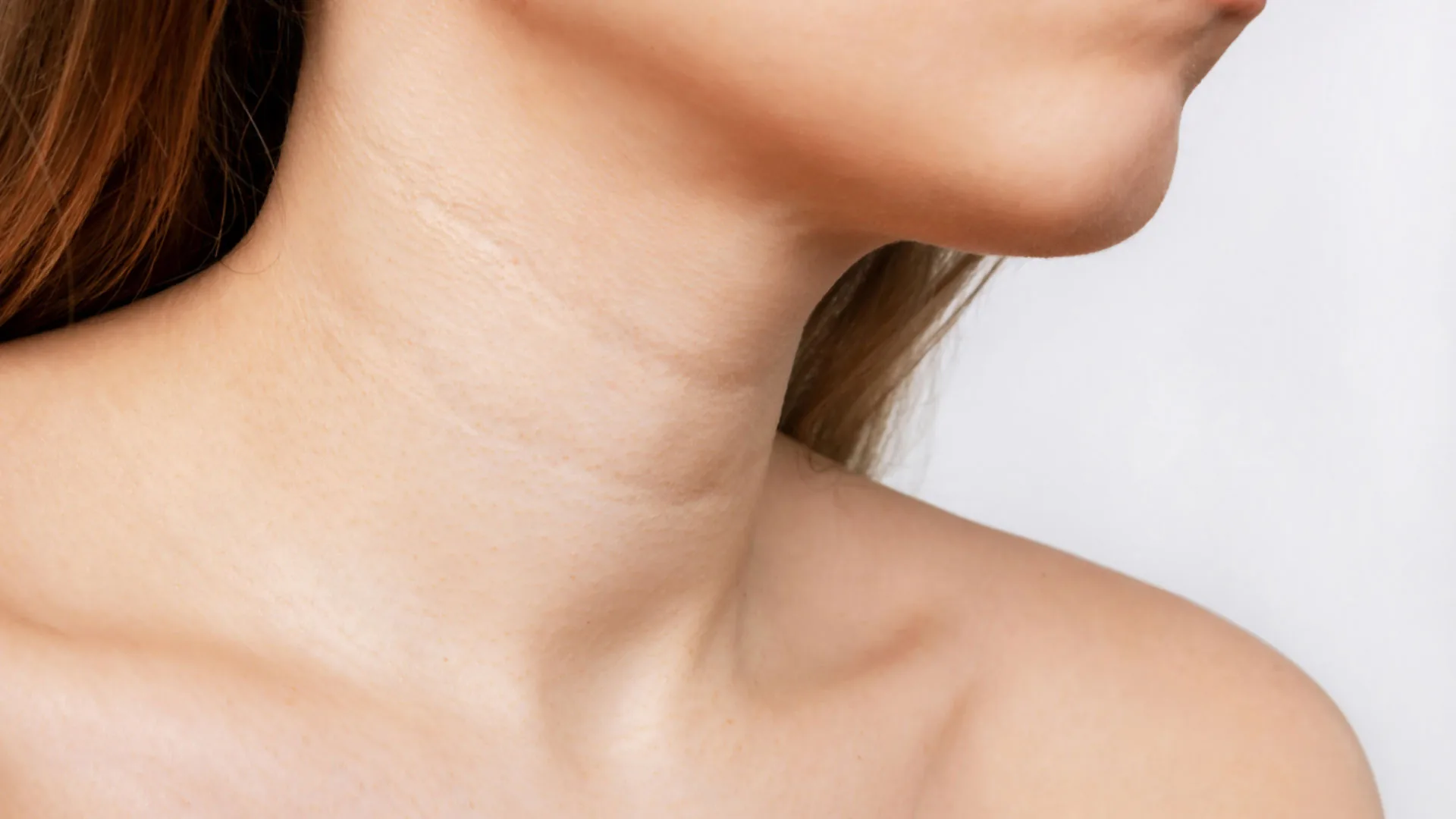 Close-up of a woman's neck and jawline in soft light