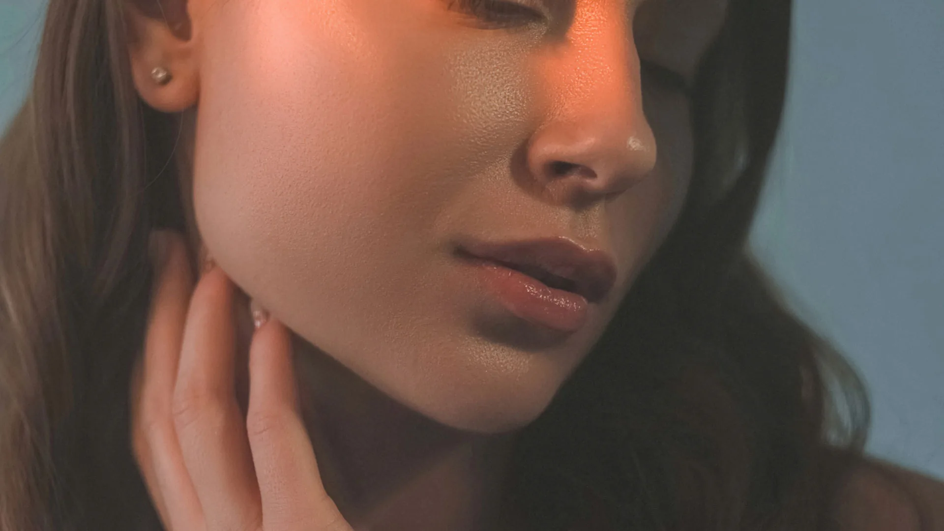 Woman's lips, nose, and cheek in warm light, eyes out of frame