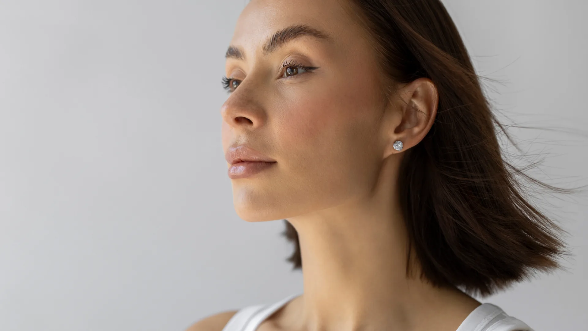 Woman with a chin-length bob looking off to the side in soft light