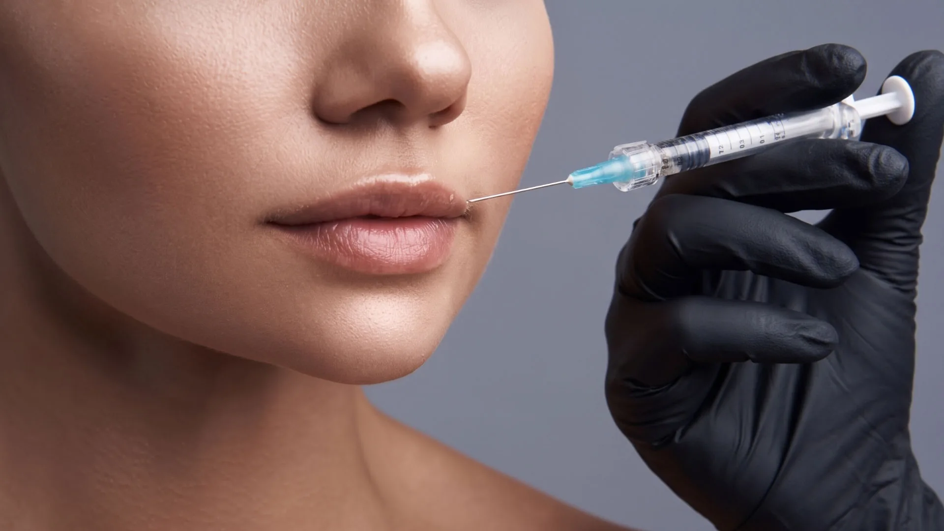Gloved hand holding a syringe near a woman's lips