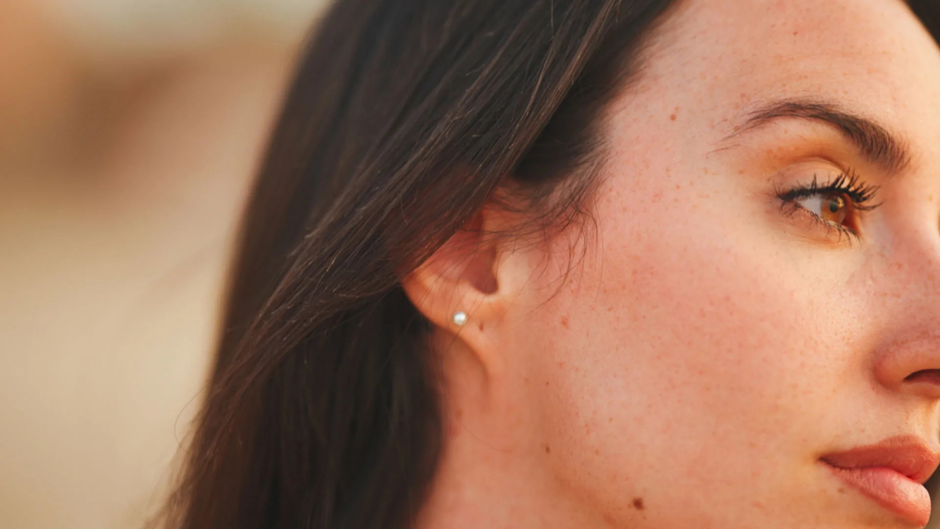Close-up of a woman's ear and cheek in three-quarter profile