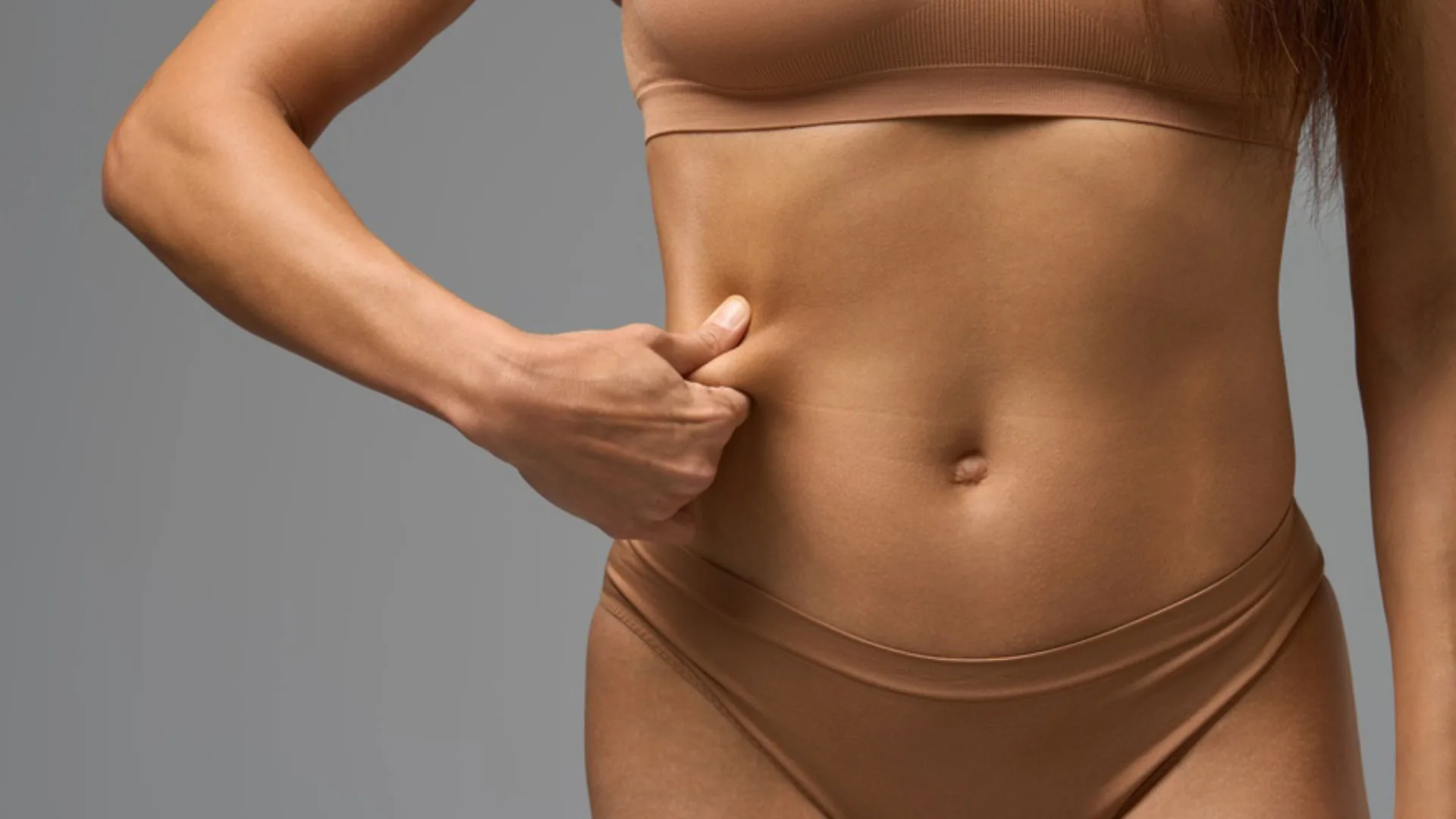 Woman pinching the skin at the side of her waist
