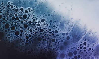 Close-up of blue and black bubbles or foam with a gradient background.