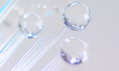 Close-up of clear glass fiber optic strands with glowing tips on a light background.