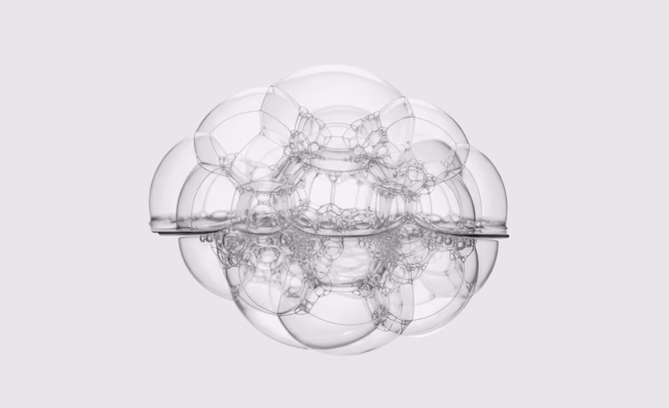 Cluster of transparent soap bubbles forming an intricate spherical pattern on a light background.