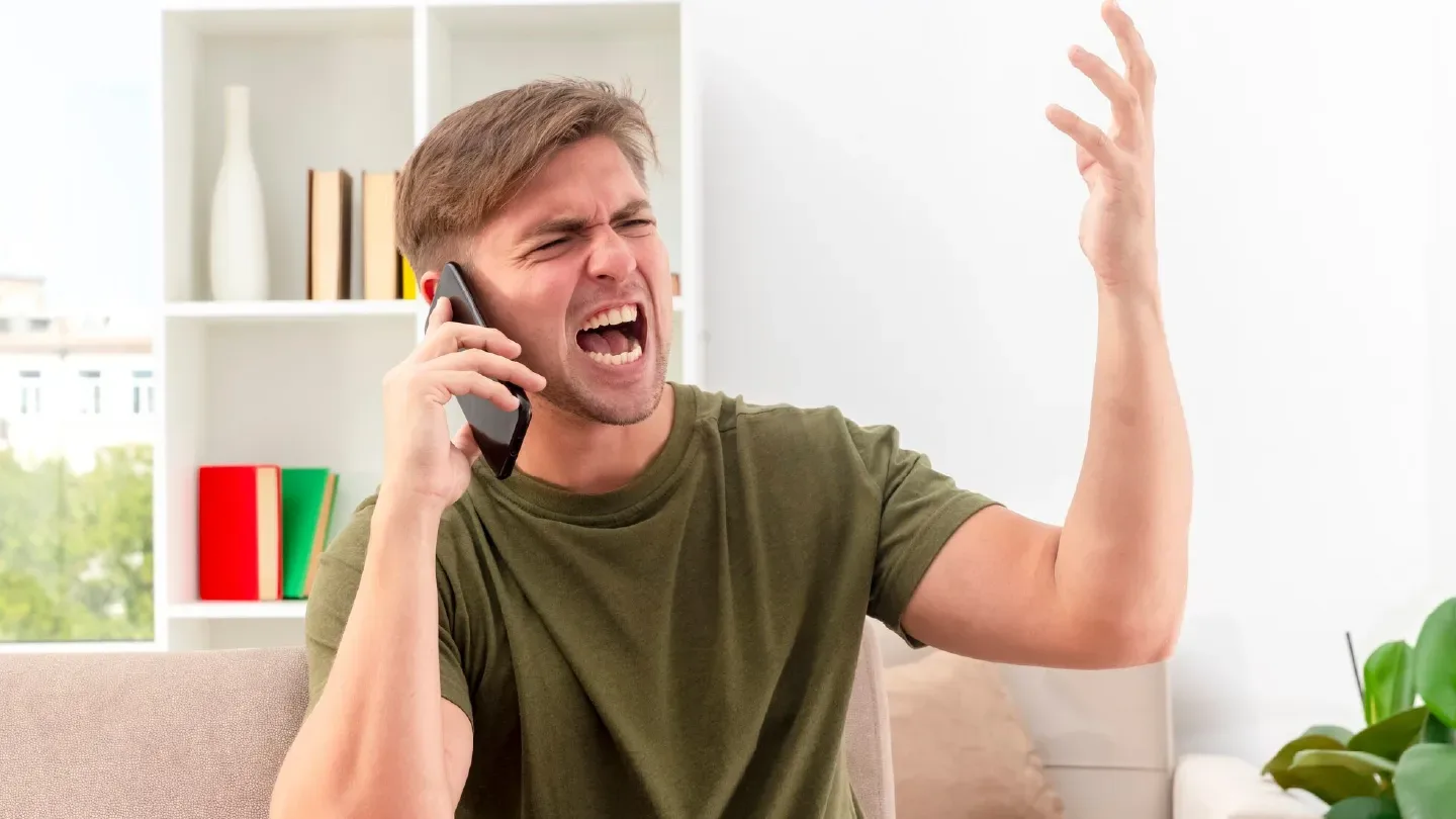 Cliente frustrado durante una llamada telefónica que puede ser optimizada con vozy.ia.