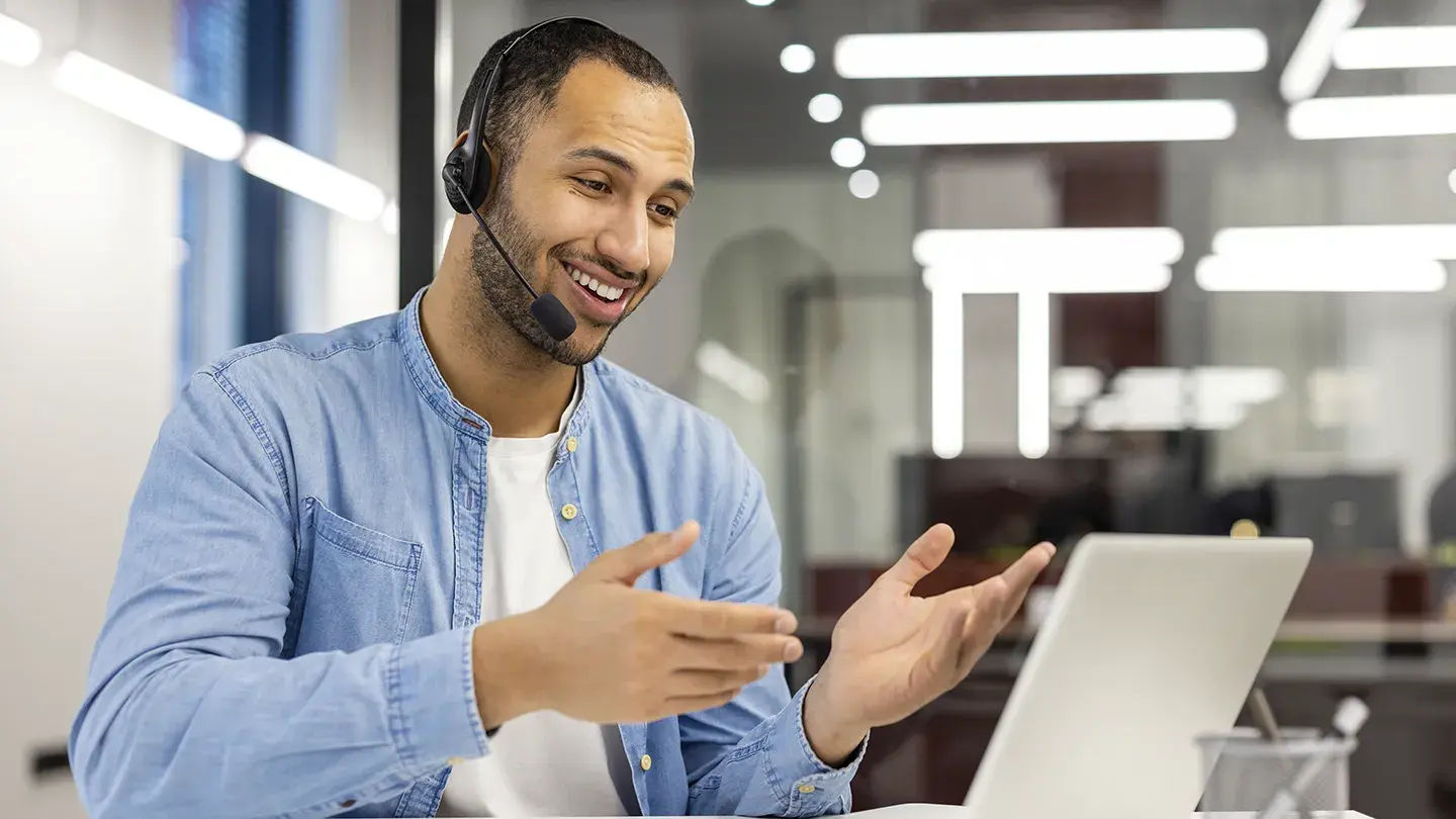 Ejecutivo usando headset en videollamada para atención al cliente con vozy.ia.