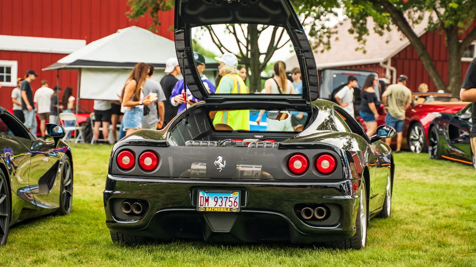 A Ferrari with its engine cover raised among visitors at a Chicago car show