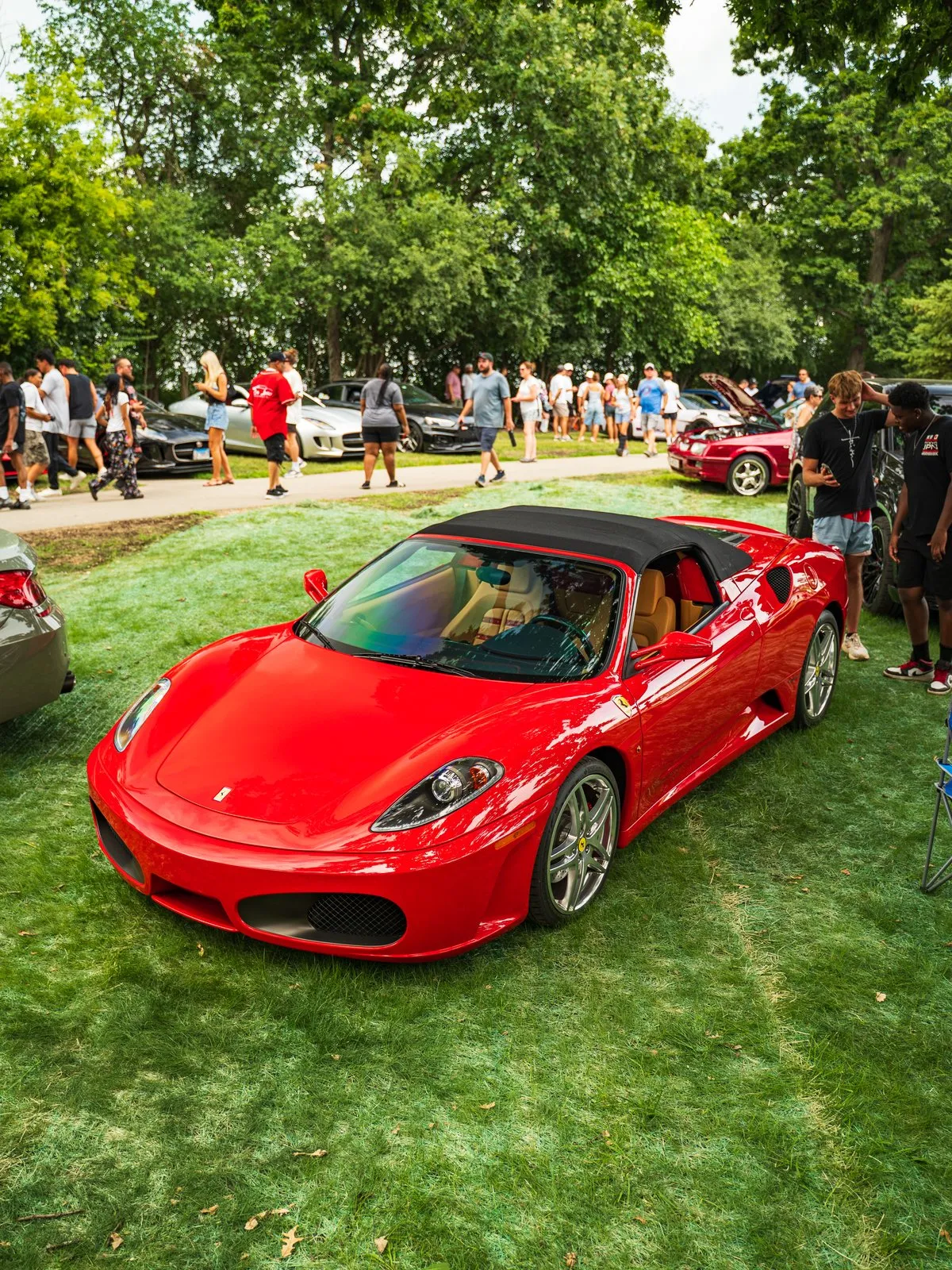 A red Ferrari F430 on the lawn with spectators