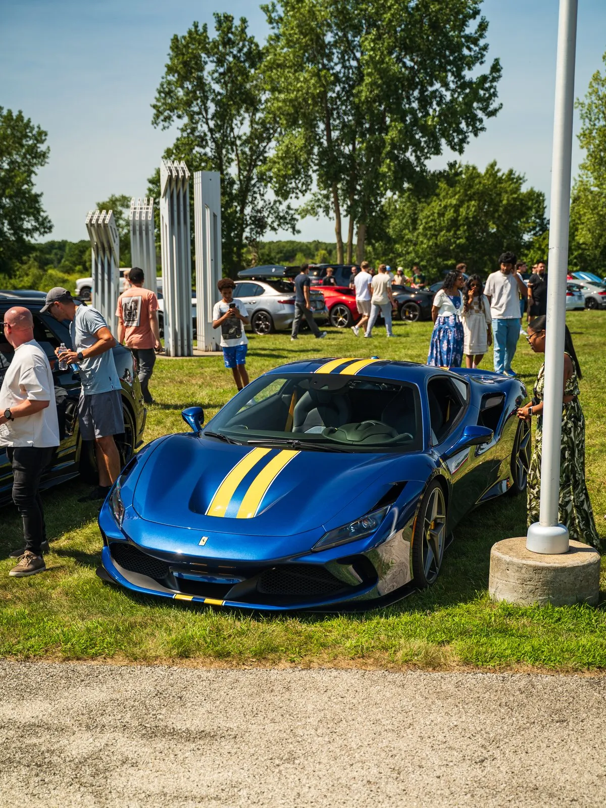 A blue Ferrari with yellow stripes and spectators