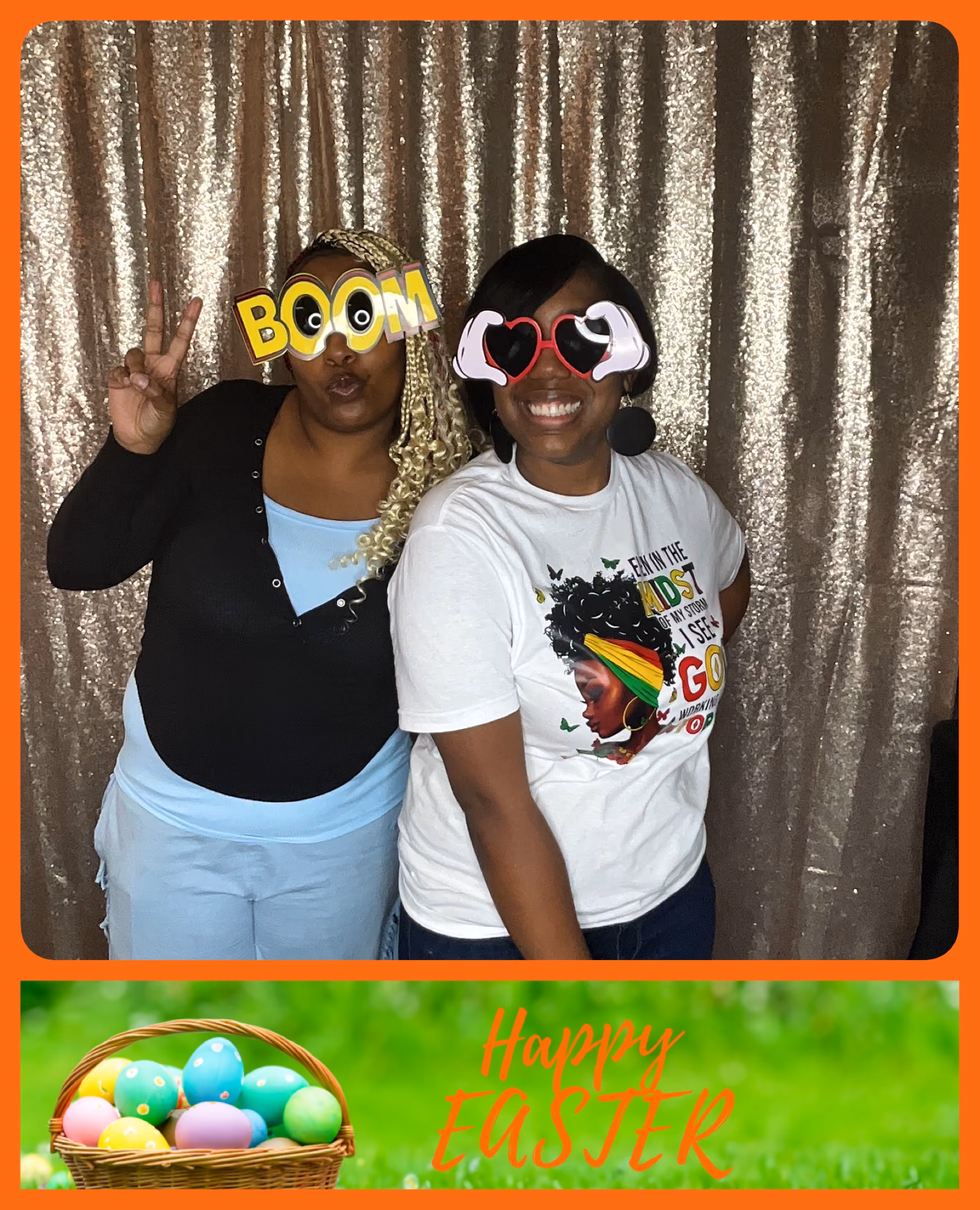 Two women wearing funny glasses pose smiling in front of a sparkly backdrop with a Happy Easter frame.