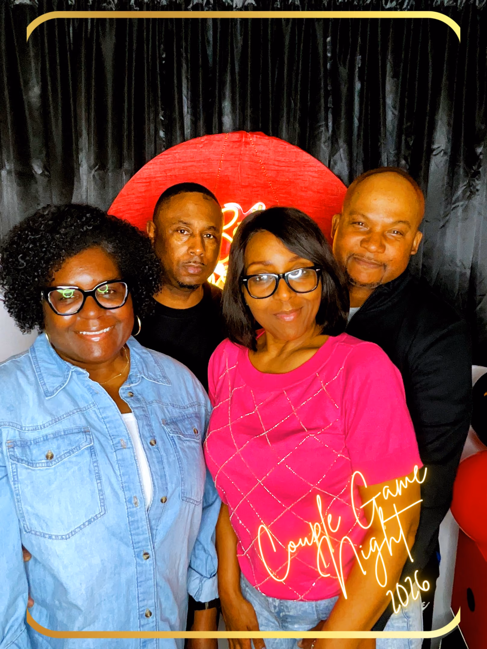 Four adults smiling and posing in front of a red circle backdrop with 'Couple Game Night 2026' text.