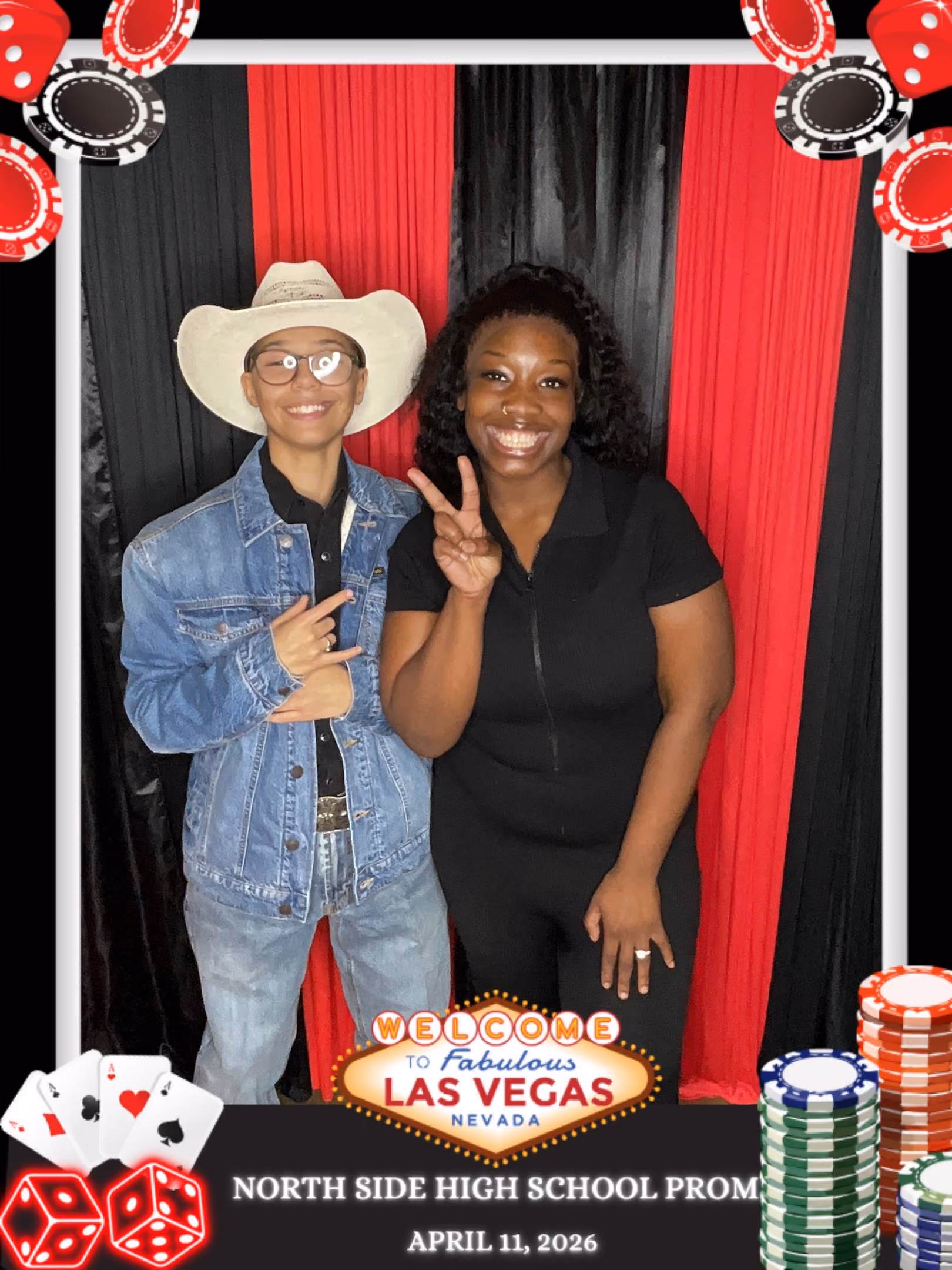 Two young people smiling at North Side High School prom with Las Vegas themed backdrop and poker chips