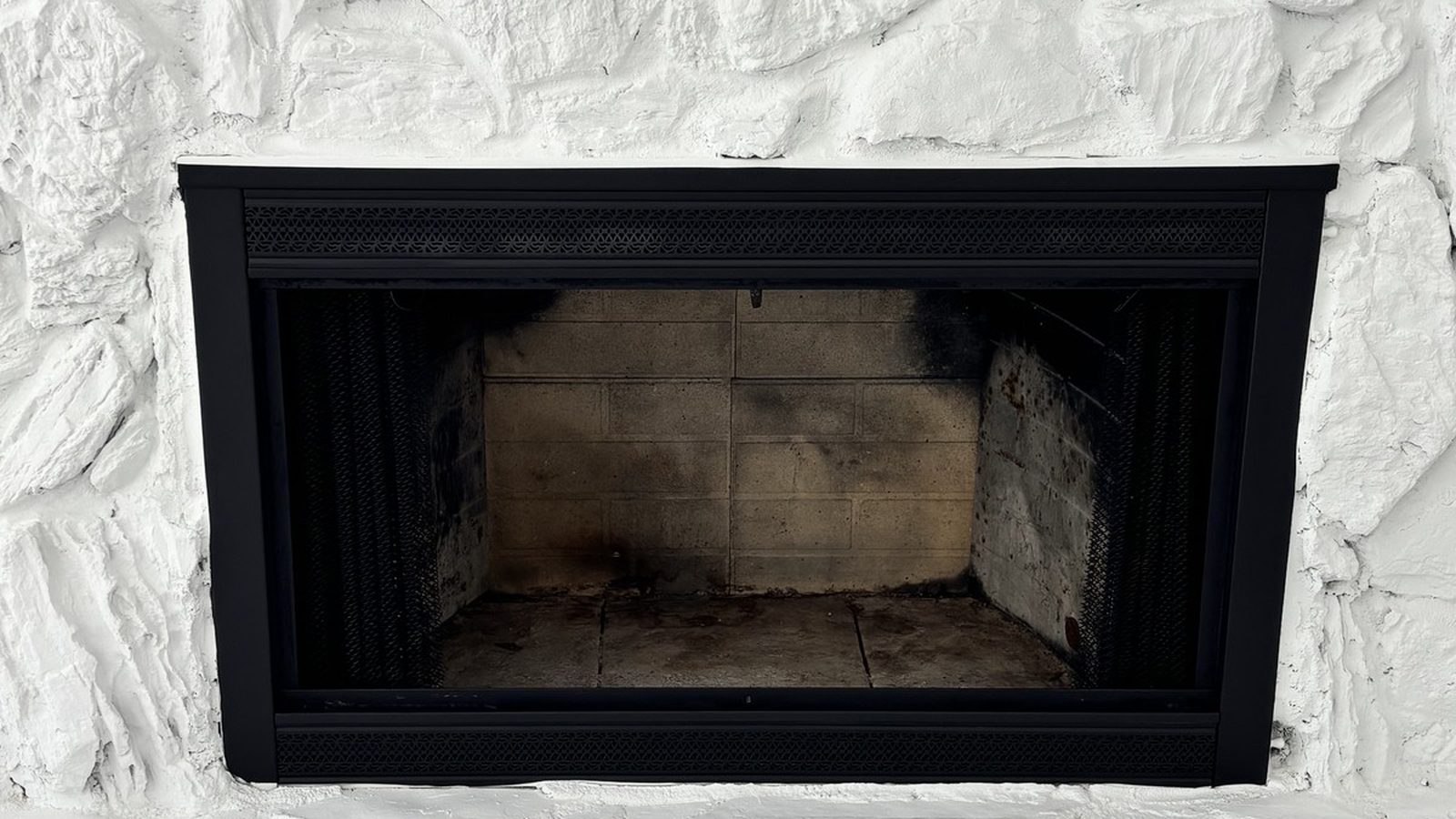 Soot-stained wood-burning firebox before a chimney sweep