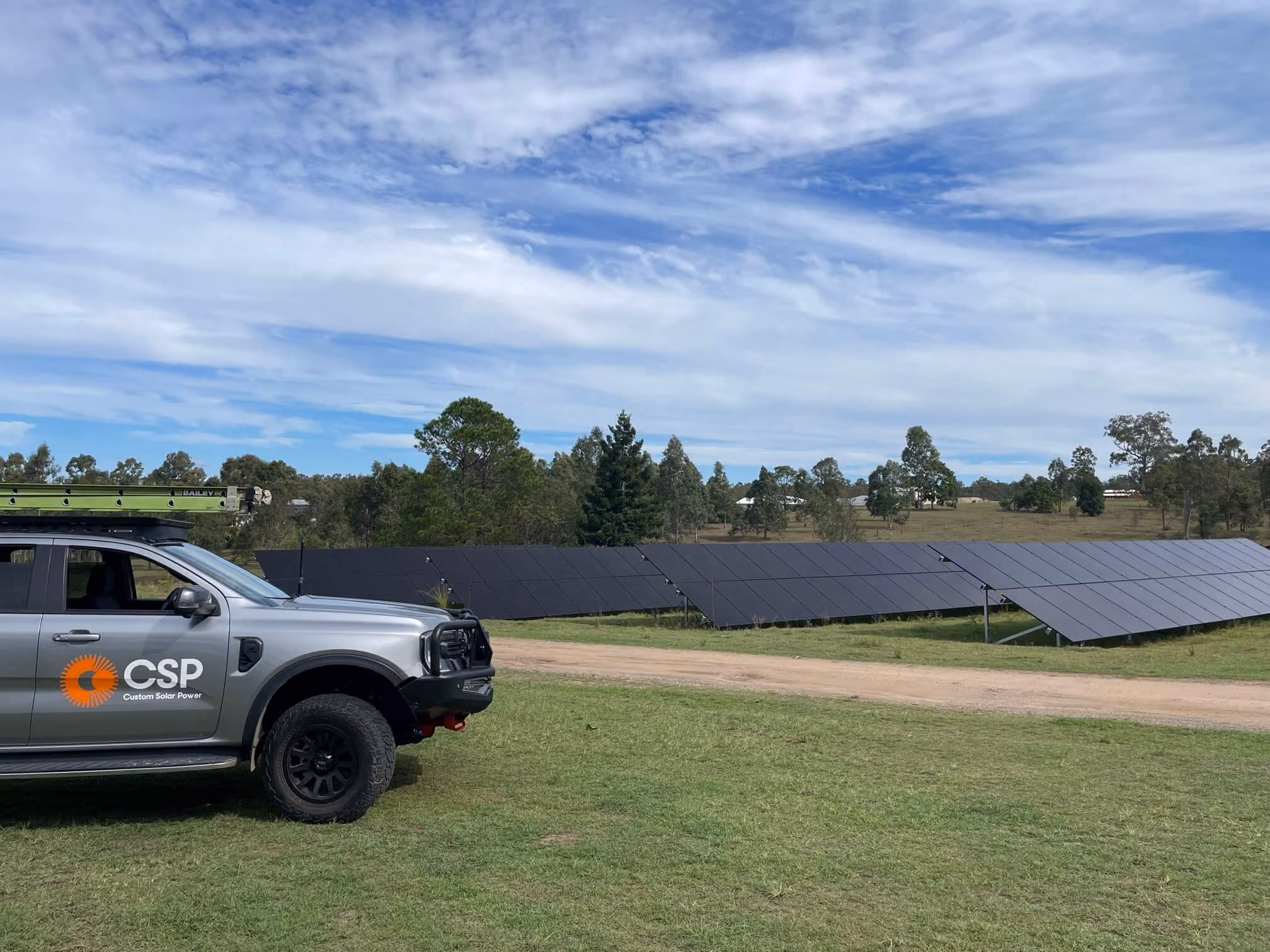 Rural Australian property with a ground-mounted solar array and battery storage system providing energy independence.
