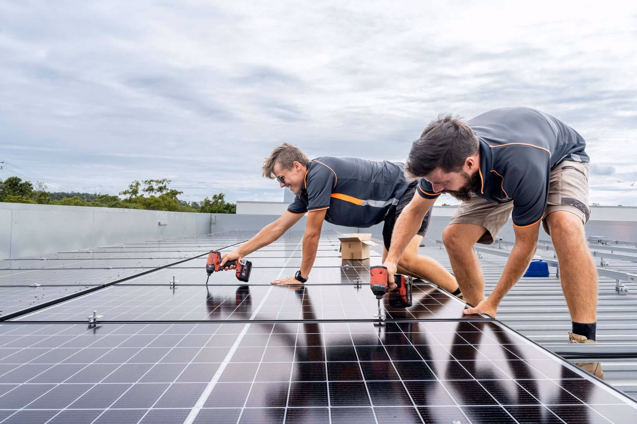 Professional installer fitting solar panels to the roof of an Australian home while wearing high-visibility safety equipment.