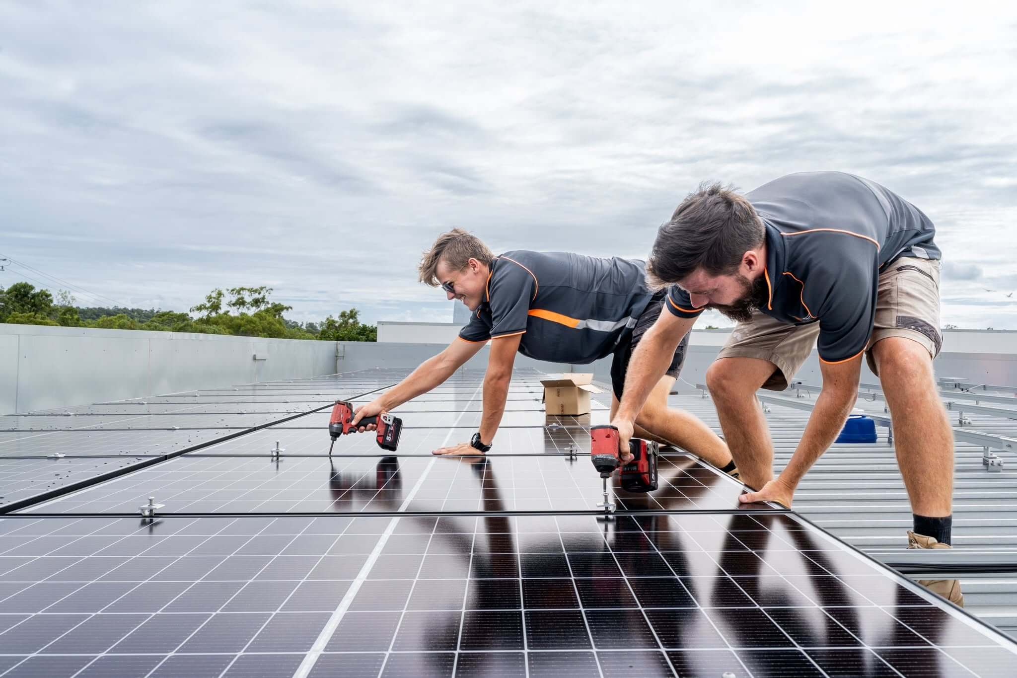 Professional installer fitting solar panels to the roof of an Australian home while wearing high-visibility safety equipment.