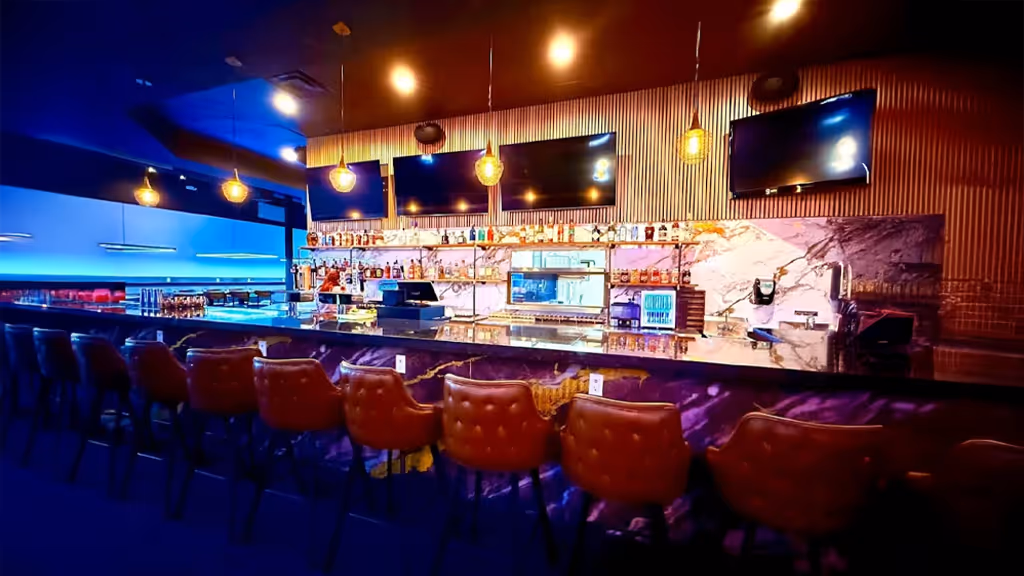 A bar with a blue light and a purple wall.
