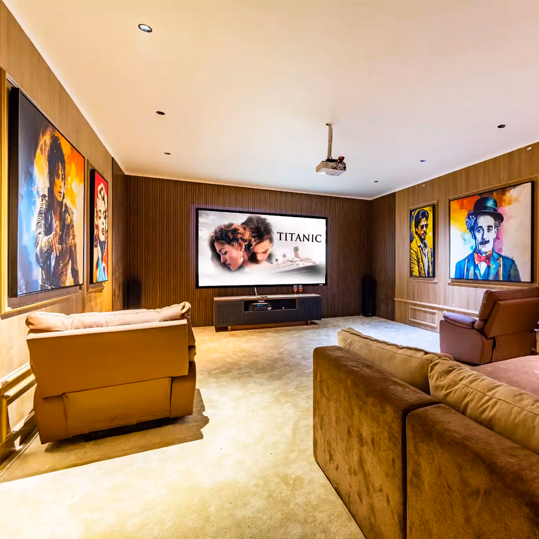 Home theater with beige sofas, projector, and movie poster of Titanic on the screen.
