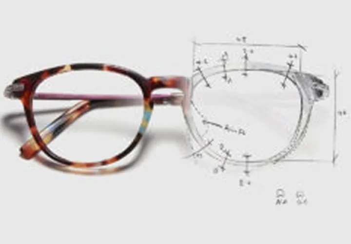 Brown tortoiseshell eyeglasses with a sketched technical drawing of the right lens.