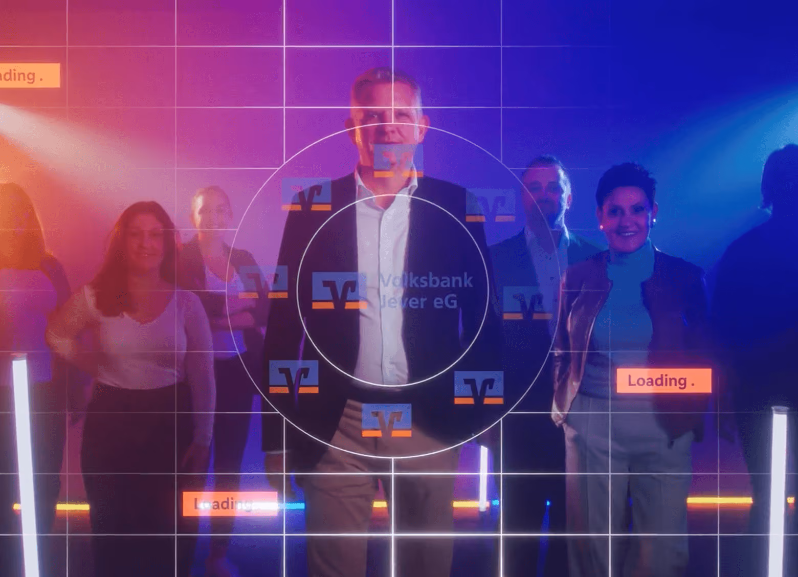 Gruppe von Menschen steht in bunter, futuristischer Beleuchtung mit Volksbank-Logos und Ladebalken im Vordergrund.