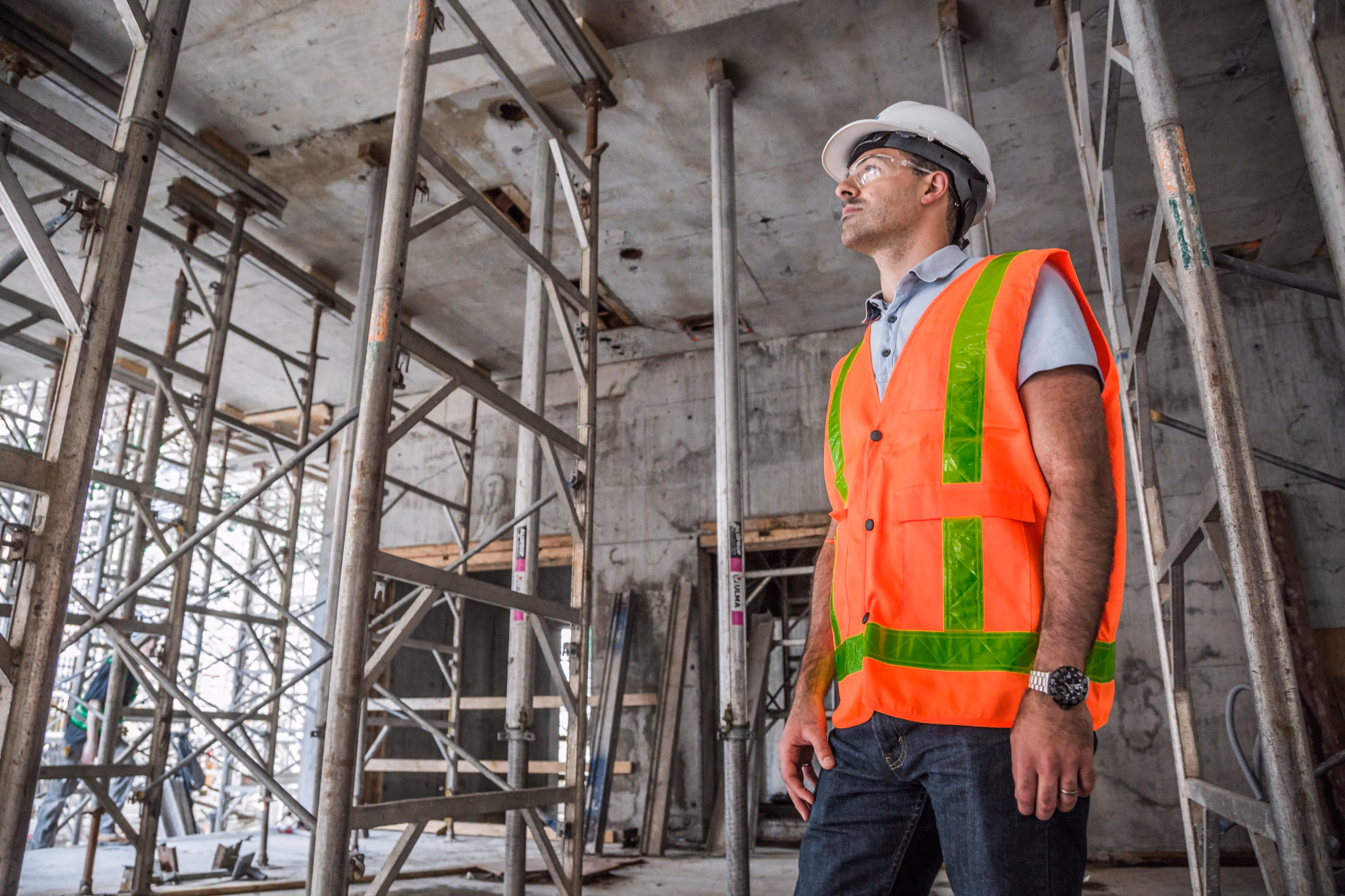 Site manager in a hi-vis vest and hard hat inside a building under construction