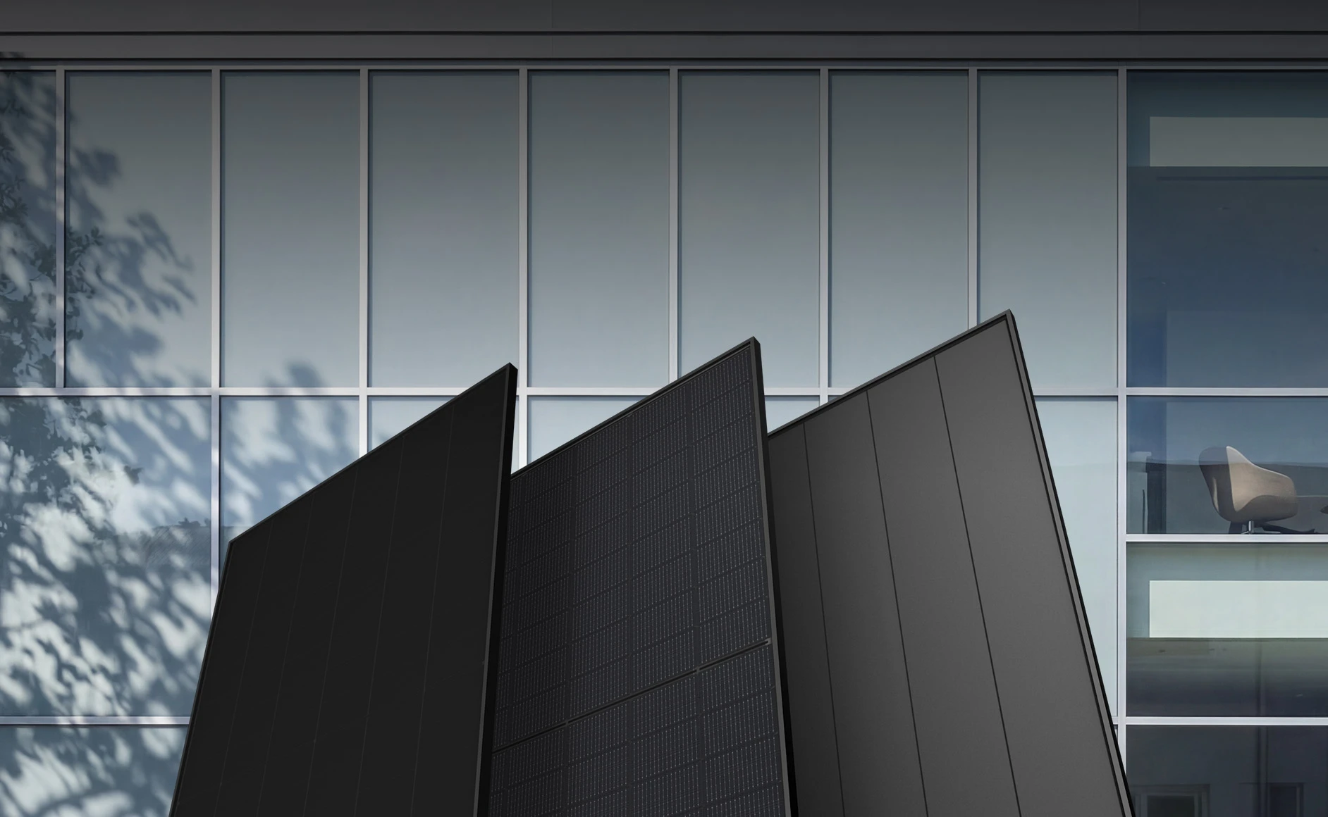 Three TCL solar panels standing against a glass office facade