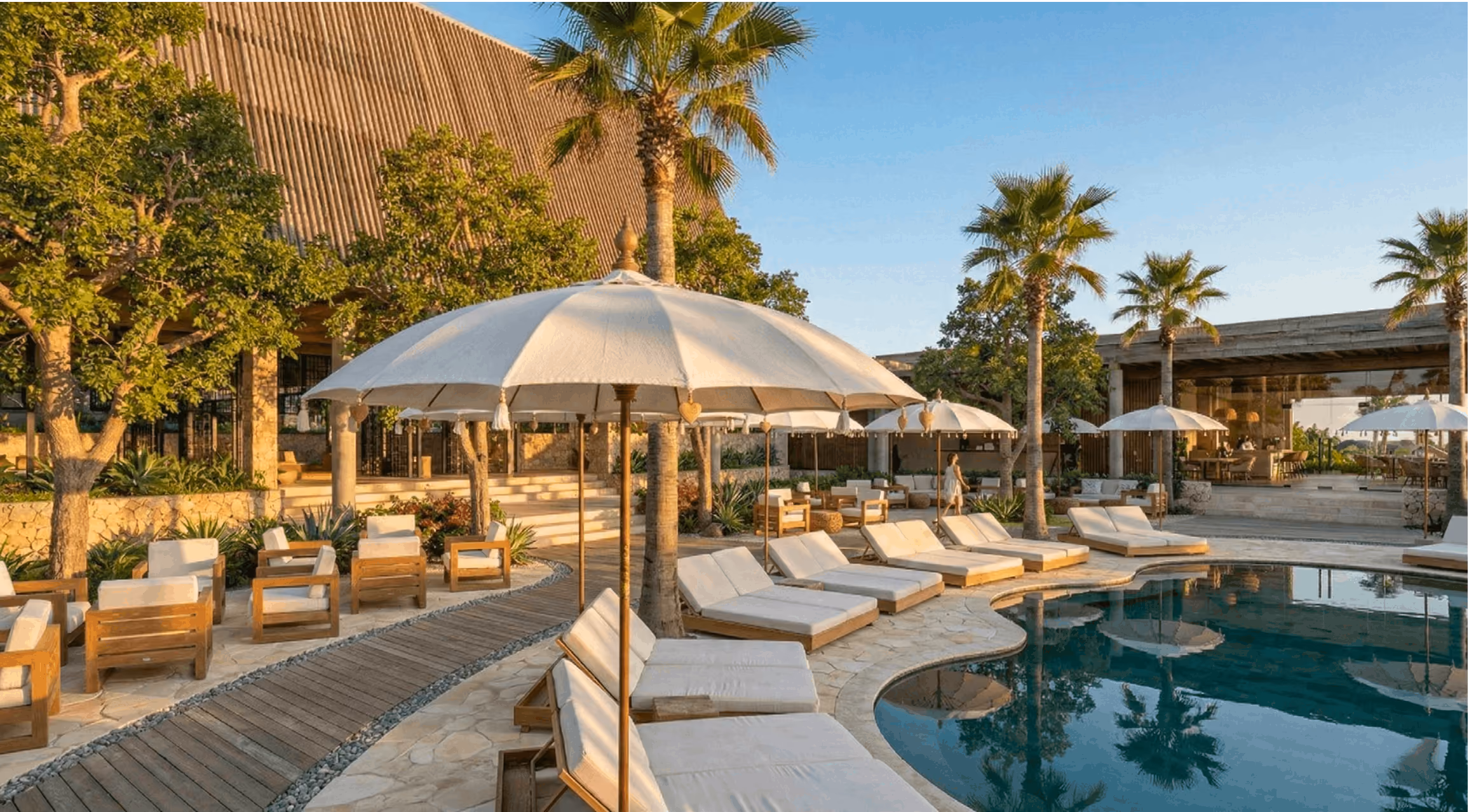 Poolside lounge area with umbrellas and daybeds at Laga