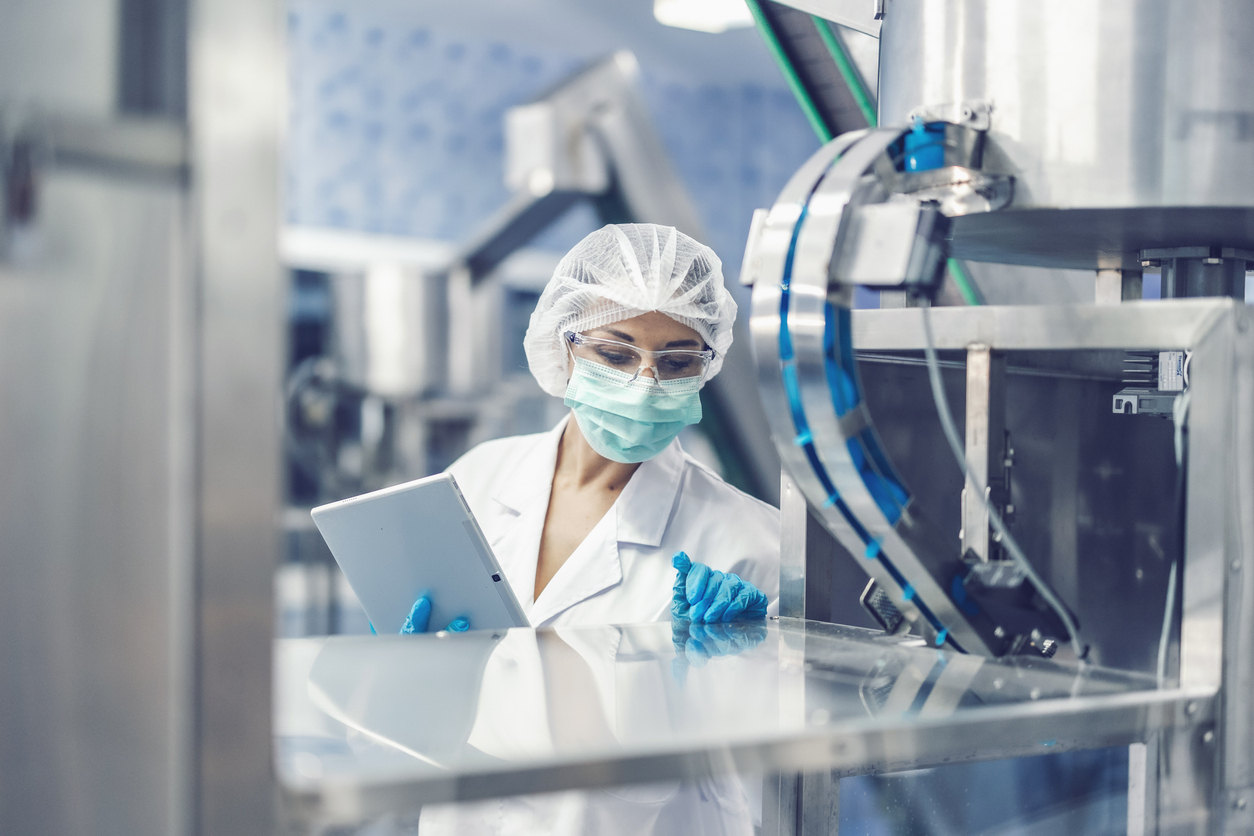 Eine Mitarbeiterin in Schutzkleidung kontrolliert eine Anlage in der Arzneimittelproduktion: Generika werden nach verbindlichen Qualitätsstandards hergestellt und geprüft. Copyright: © coffeekai/iStock