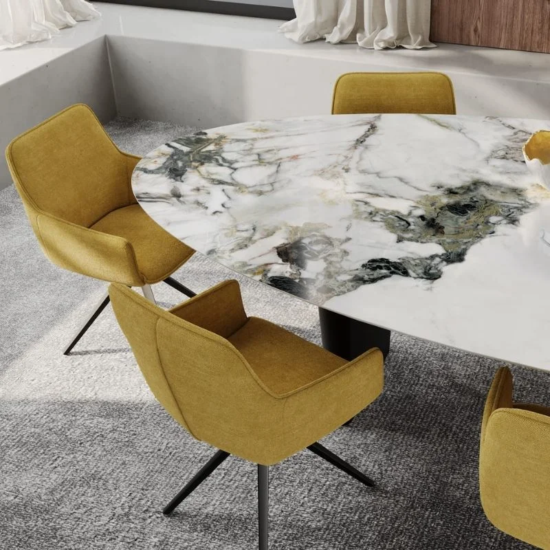 Quatre chaises Amsterdam de Akante jaune moutarde disposées autour d'une table ronde en marbre blanc à pieds noirs.
