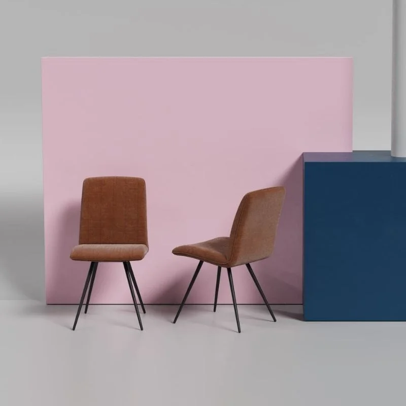 Deux chaises Dortmund Akante terracotta à pieds en métal noir, placées contre un mur rose et à côté d'un bloc bleu.