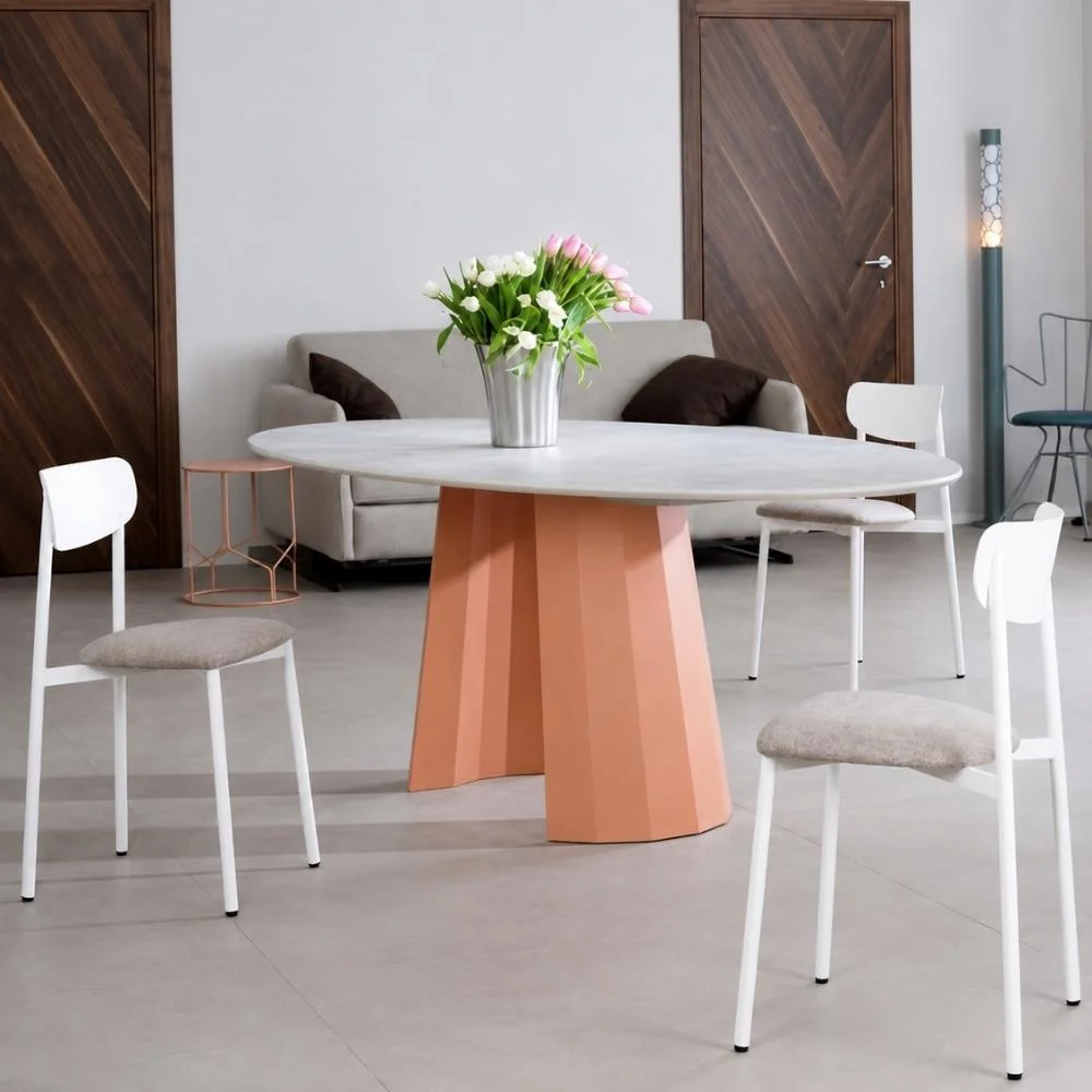 Table de salle à manger ronde avec un vase de fleurs en centre de table, entourée de quatre chaises blanches, dans un séjour.