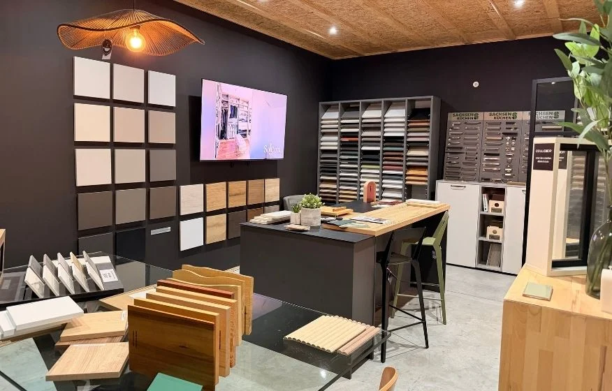 Intérieur de la matériauthèque de So!cozi avec différents échantillons et une grande table snack.