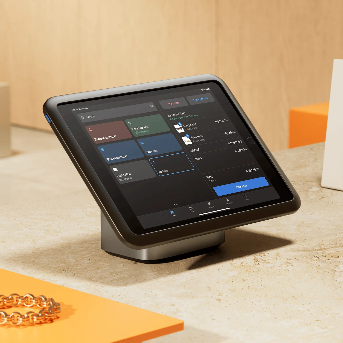 Tablet with a point-of-sale software showing customer cart and product options on a countertop.