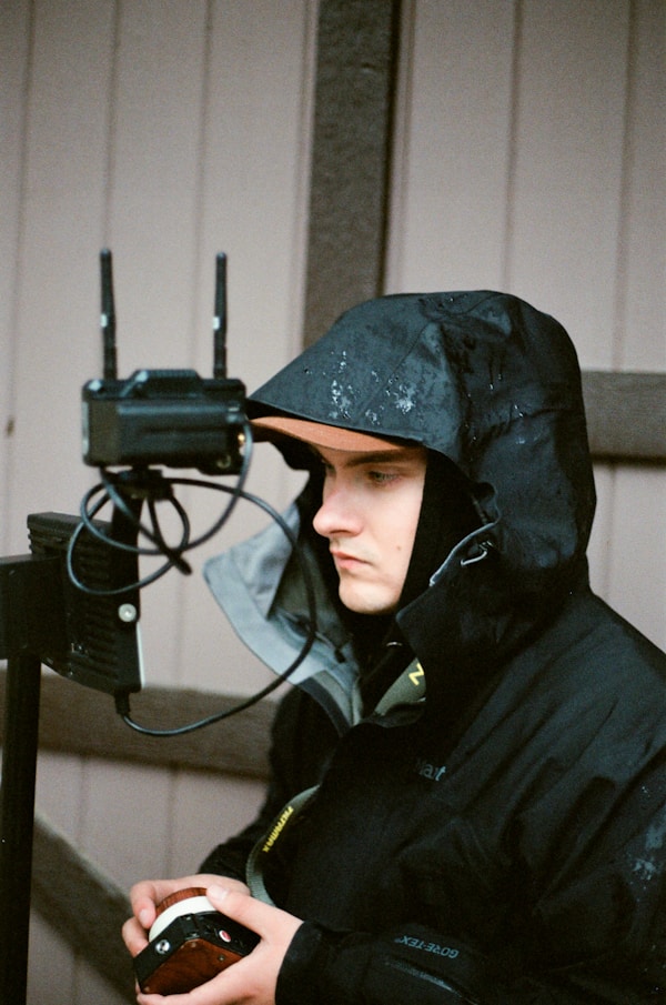 a man wearing a black helmet and holding a phone