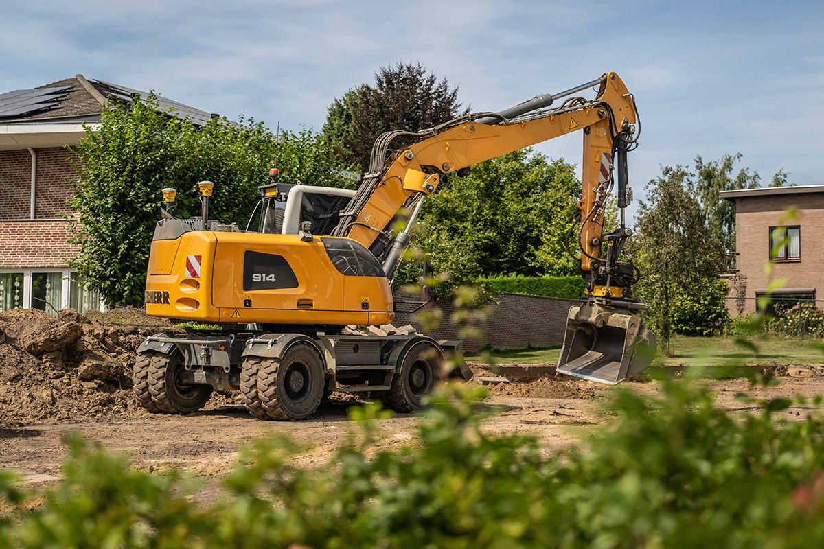 Wheeled excavator with GNSS machine-control antennas on a construction site