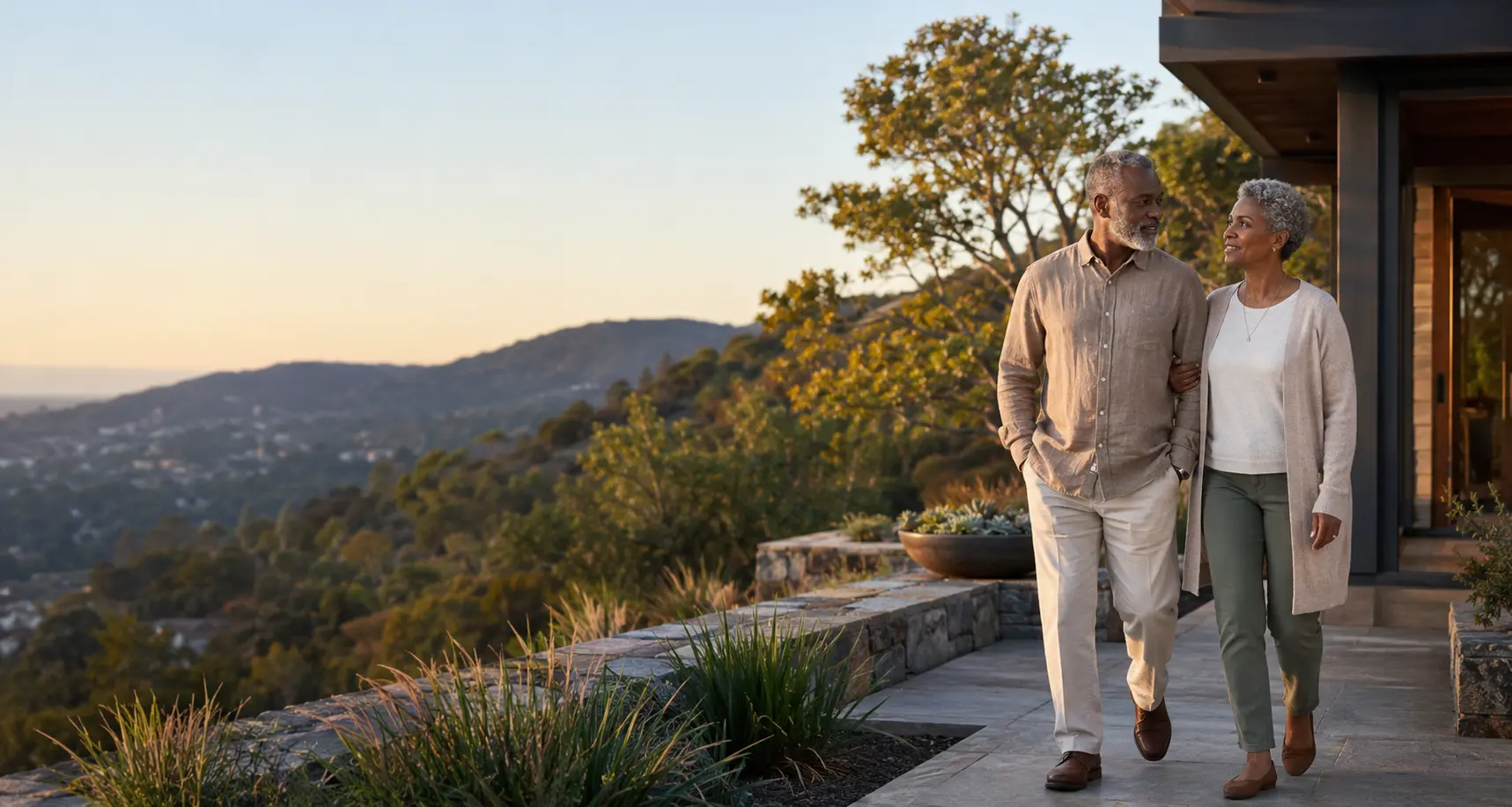A recently retired couple walking together outside their home